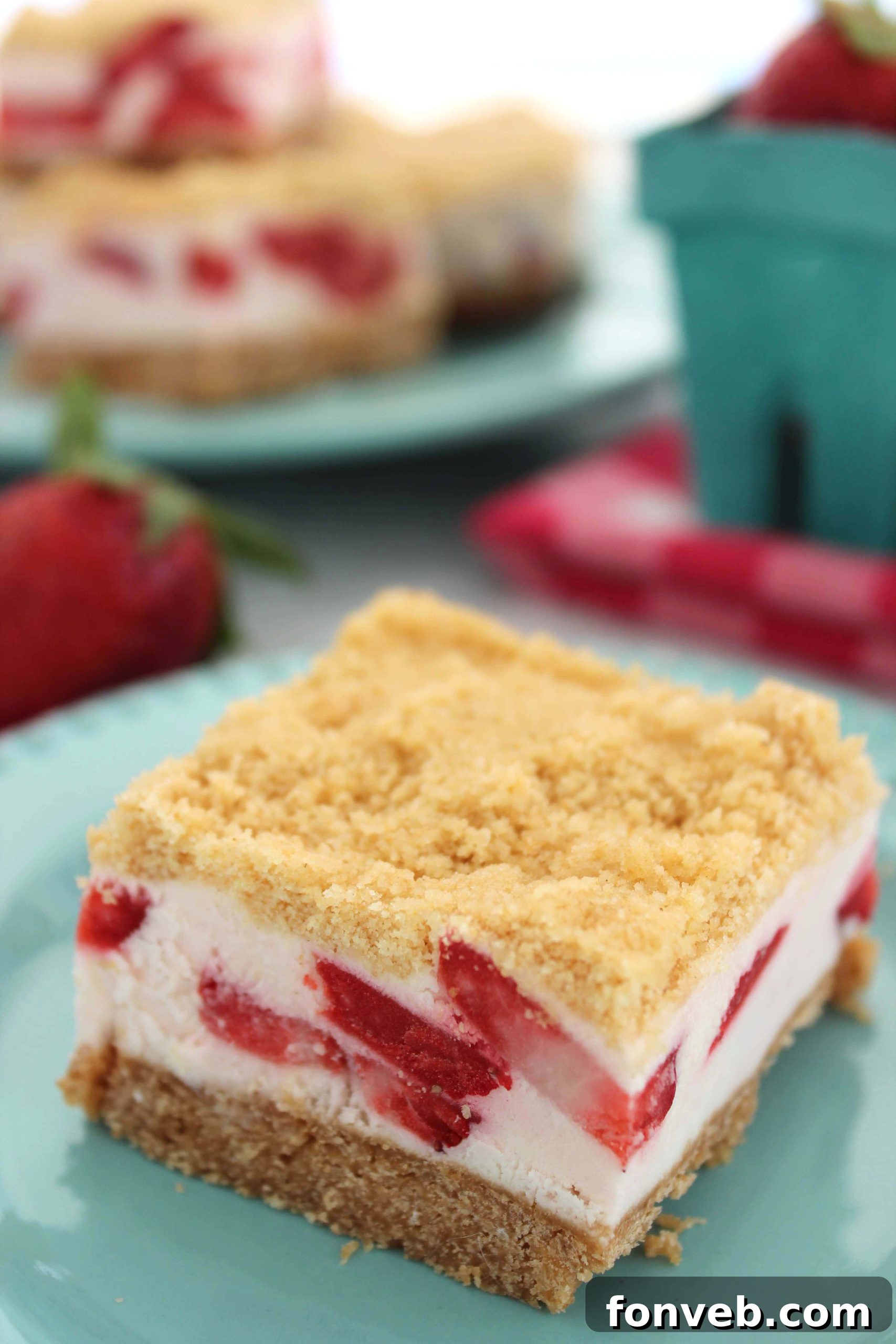 Strawberry Sugar Cookie Dream Bars 4 A single Strawberry Dream Sugar Cookie Bar cut to reveal the distinct layers: cookie crust, strawberry cheesecake filling, and crumb topping.