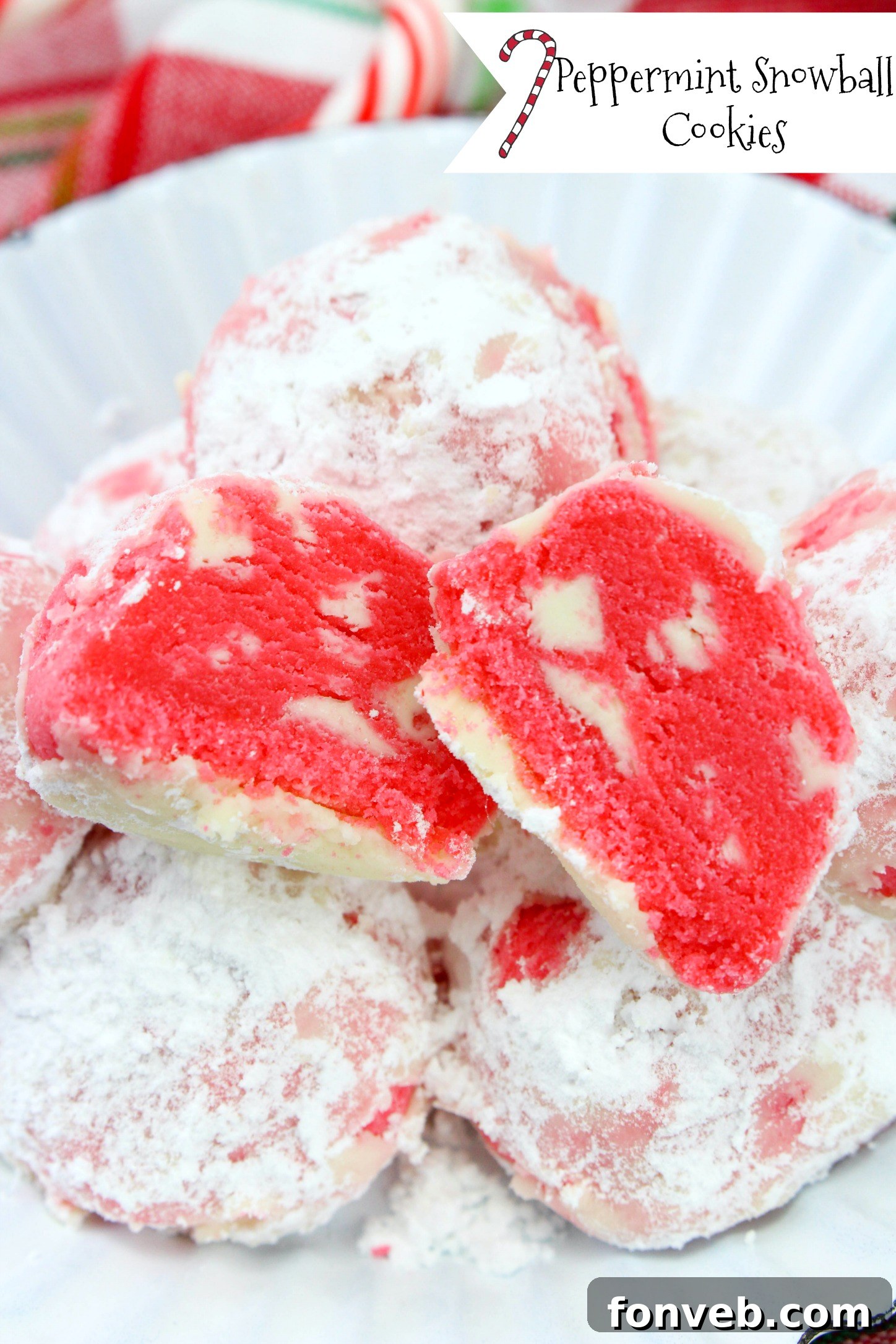 Winter Wonderland Shortbread Snowballs 2 Close-up of freshly baked peppermint shortbread snowball cookies dusted with powdered sugar, sitting on a parchment-lined tray.