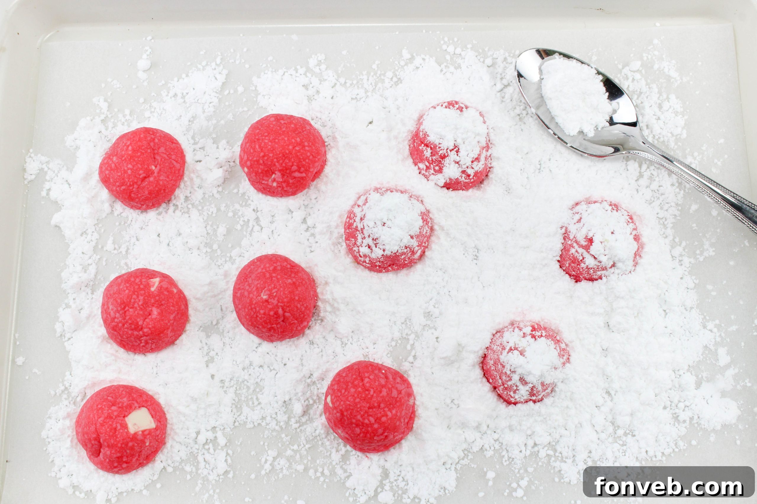 Winter Wonderland Shortbread Snowballs 3 A stack of peppermint shortbread snowball cookies, beautifully arranged and heavily dusted with powdered sugar, ready for serving.