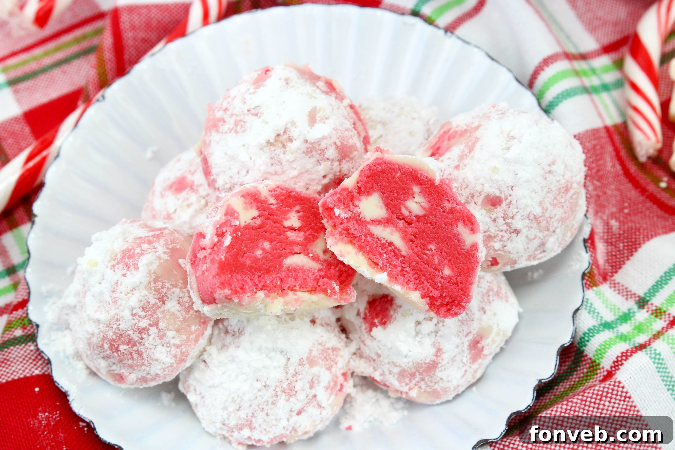 Winter Wonderland Shortbread Snowballs 4 A close-up of the interior of a peppermint shortbread snowball cookie, revealing the rich, crumbly texture and bits of peppermint chocolate.