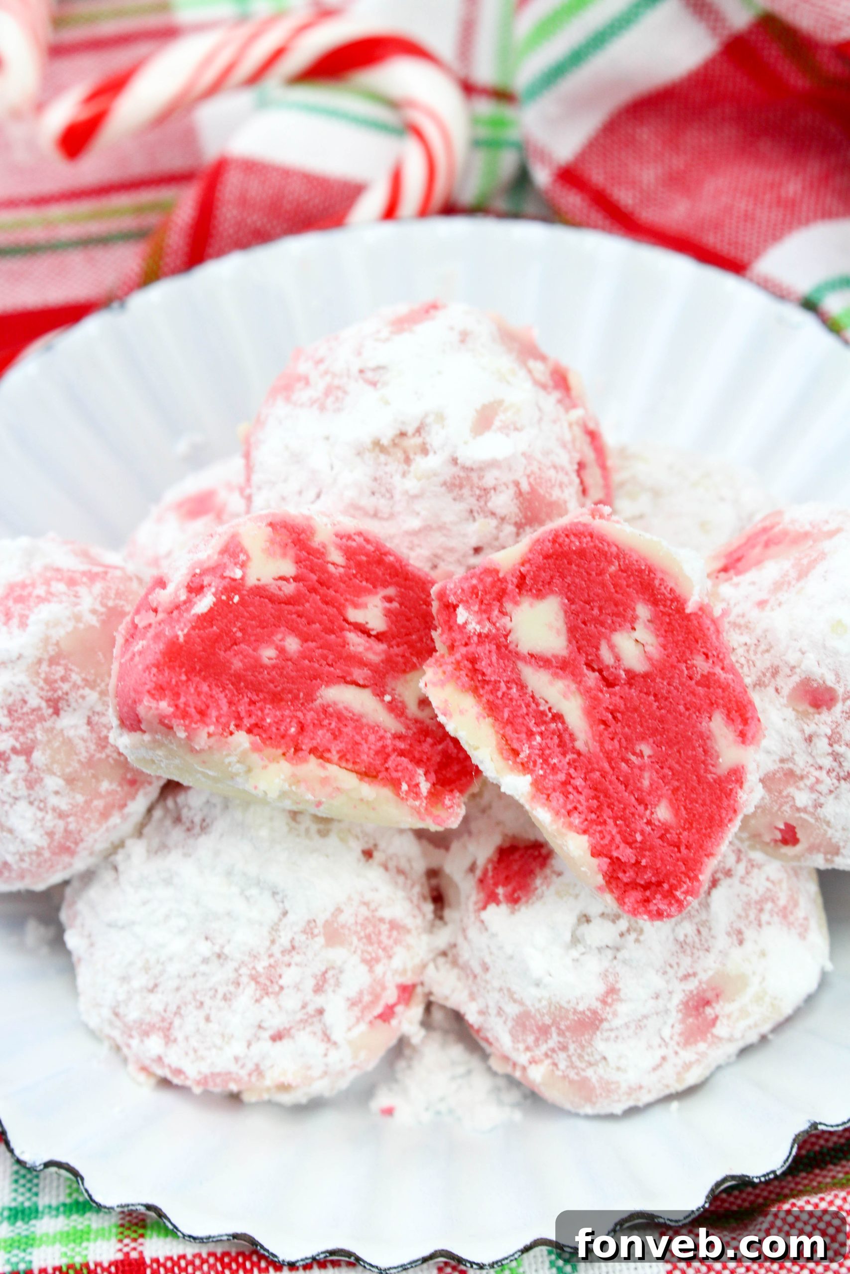 Winter Wonderland Shortbread Snowballs 6 A beautifully composed shot of peppermint shortbread snowball cookies, with some piled high and others scattered, showcasing their rustic charm.