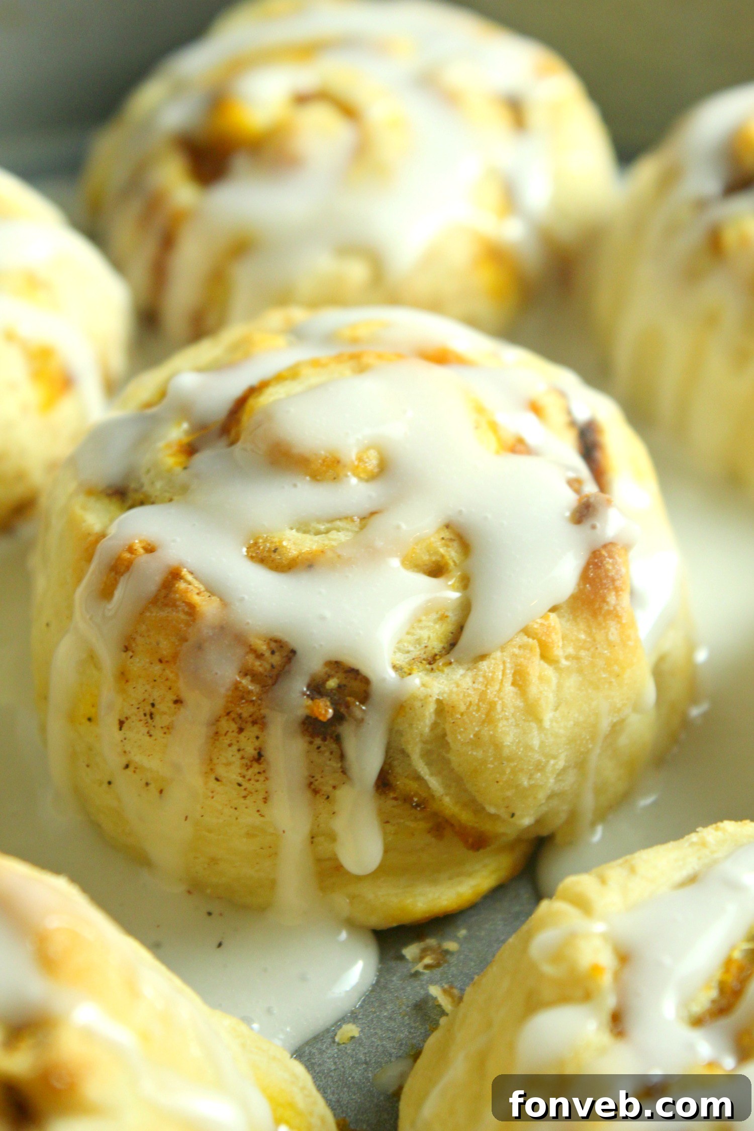 Beautifully baked pumpkin cinnamon rolls, glistening with frosting, ready to be enjoyed.