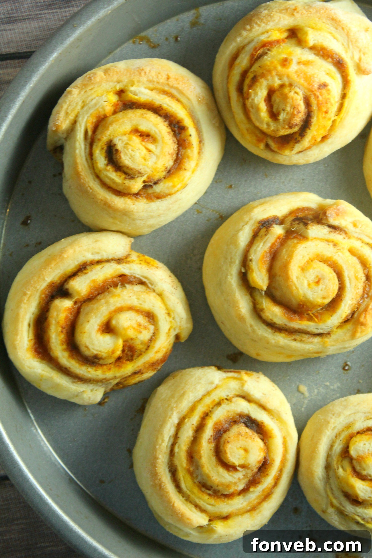 Close-up of fluffy pumpkin cinnamon rolls, showing their perfect spiral and warm color.