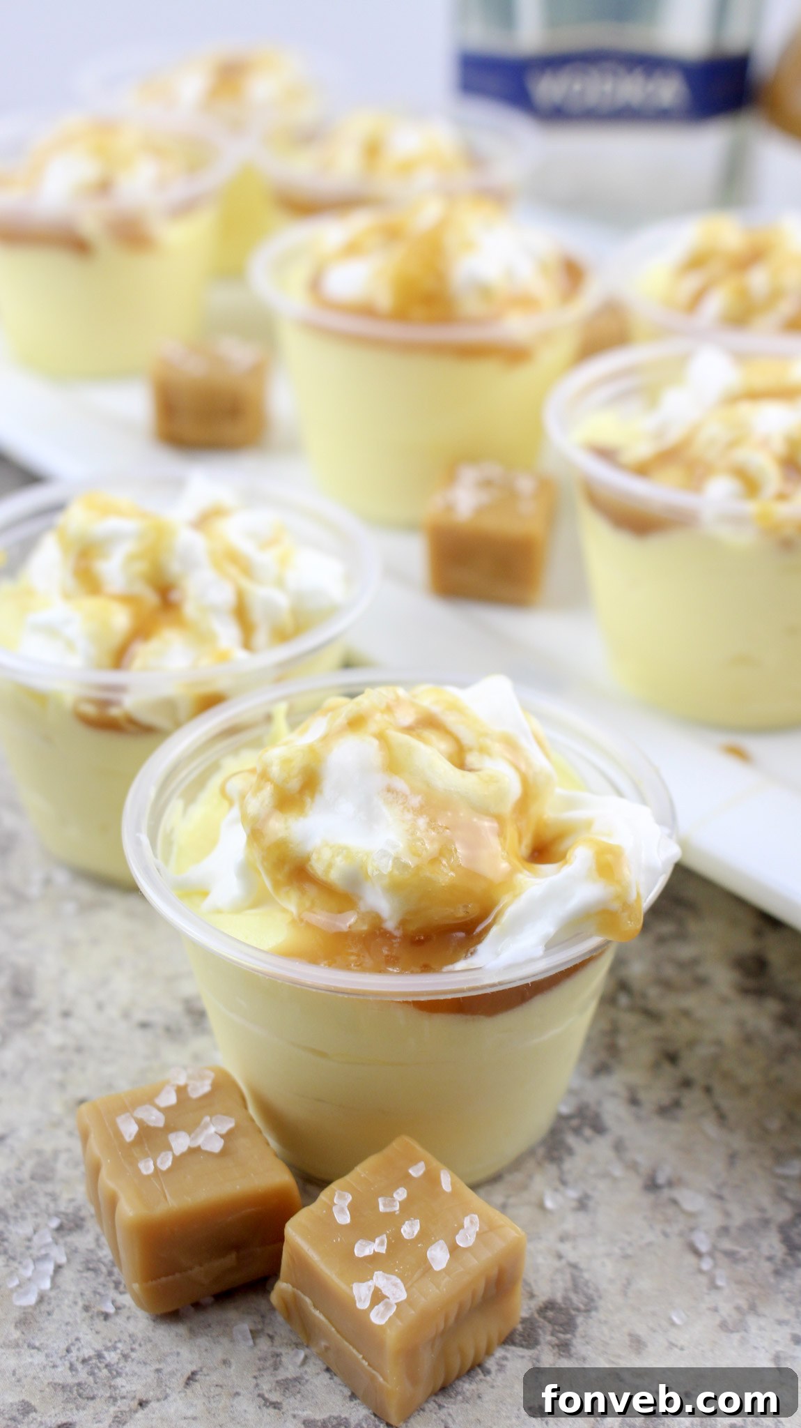 Close-up of a single Salted Caramel Pudding Shot with whipped cream and caramel drizzle