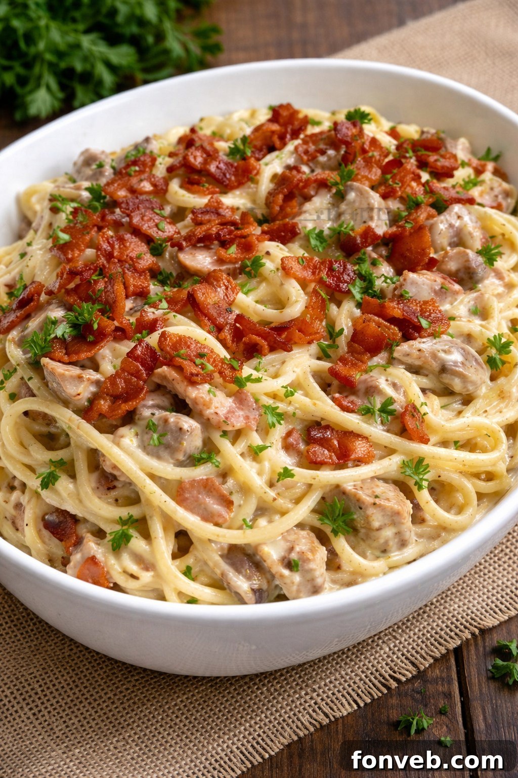 A large white bowl brimming with Creamy Bacon Carbonara with Chicken, ready to be served and enjoyed.
