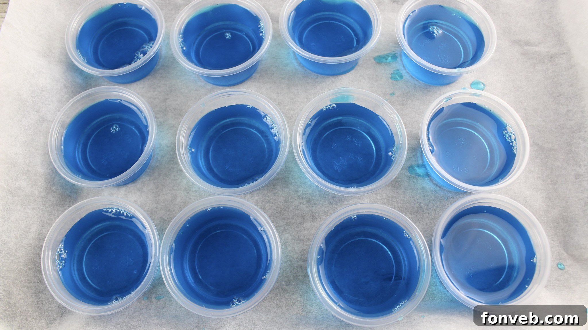 Close-up of Blue Hawaiian Jello Shots showing their beautiful blue hue and the creamy white and red cherry garnish, perfect for a tropical celebration.