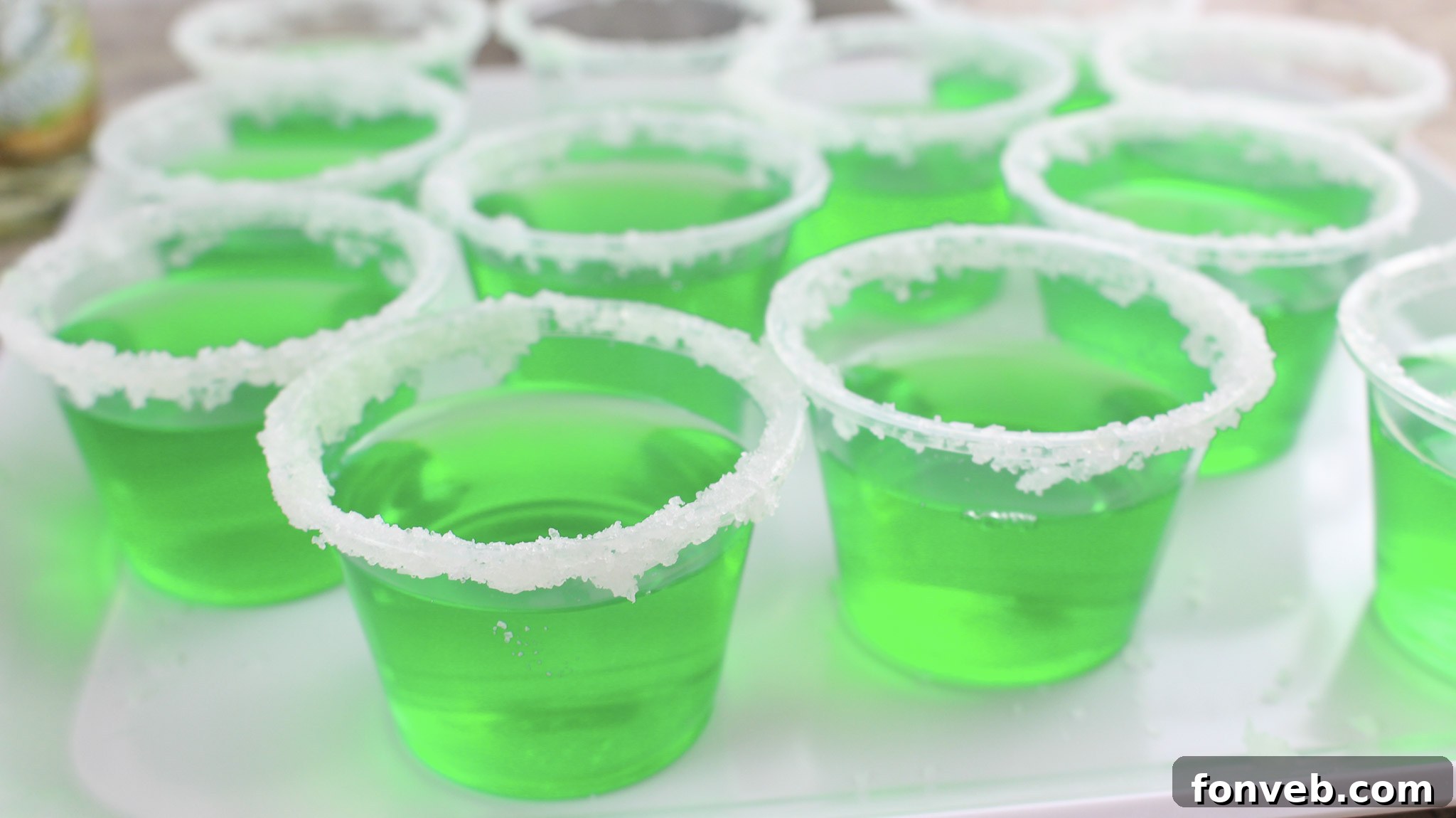 Overview of the Margarita Jello Shots with various limes and salt on the side.
