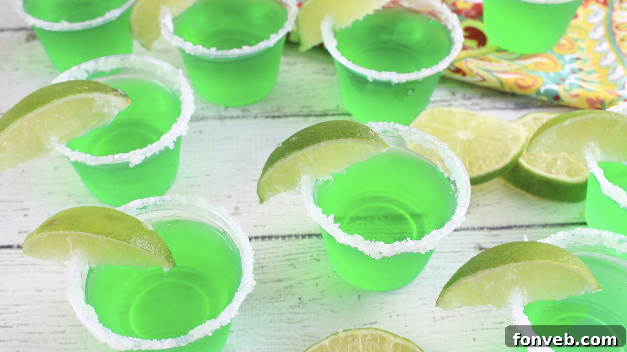 A tray filled with Margarita Jello Shots, some with salted rims, ready for a party.
