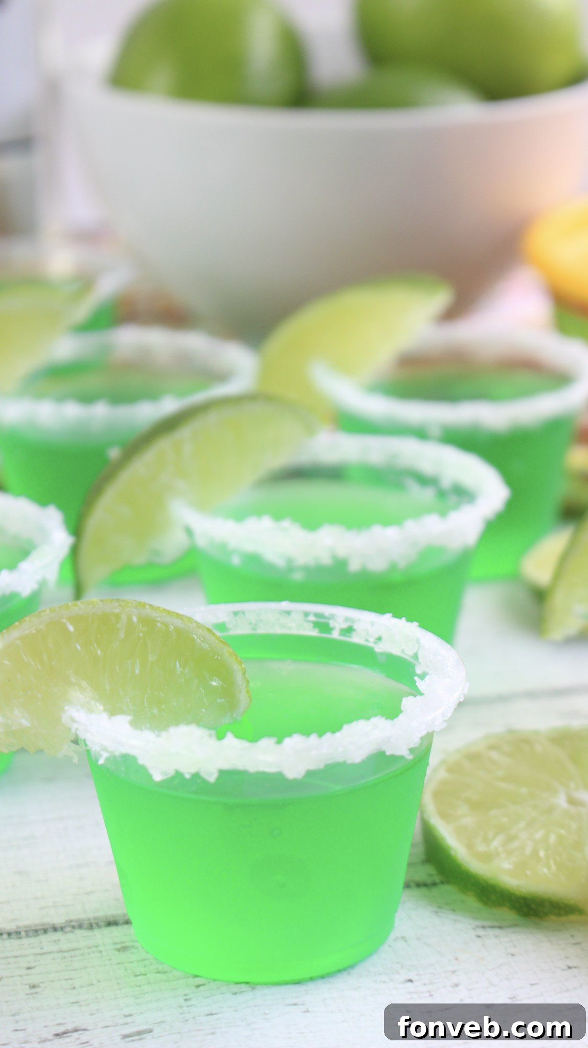 A collection of garnished Margarita Jello Shots, ready to be served at a party.