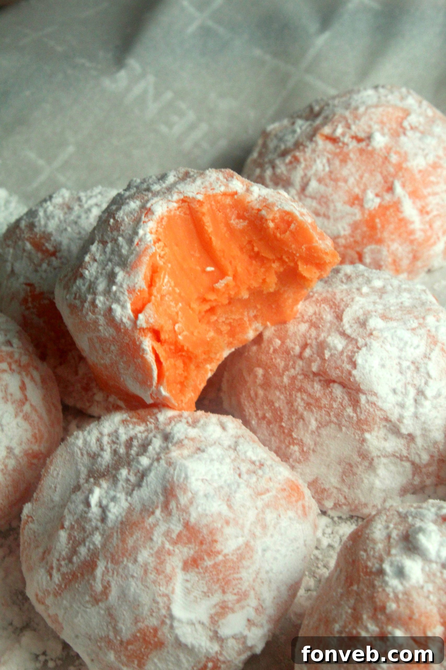 Sunny Orange Creamsicle No Bake Bites 6 Hand reaching for an orange creamsicle truffle, emphasizing its tempting appeal.