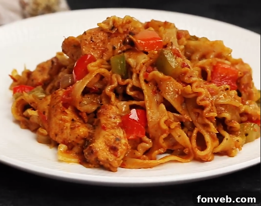 A vibrant close-up of creamy chicken fajita pasta with colorful bell peppers and seasoned chicken