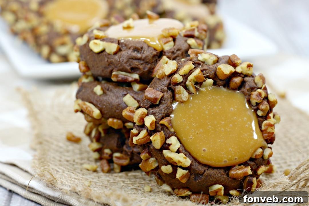 Chewy Turtle Thumbprint Delights 2 Freshly rolled chocolate cookie dough balls on parchment paper.