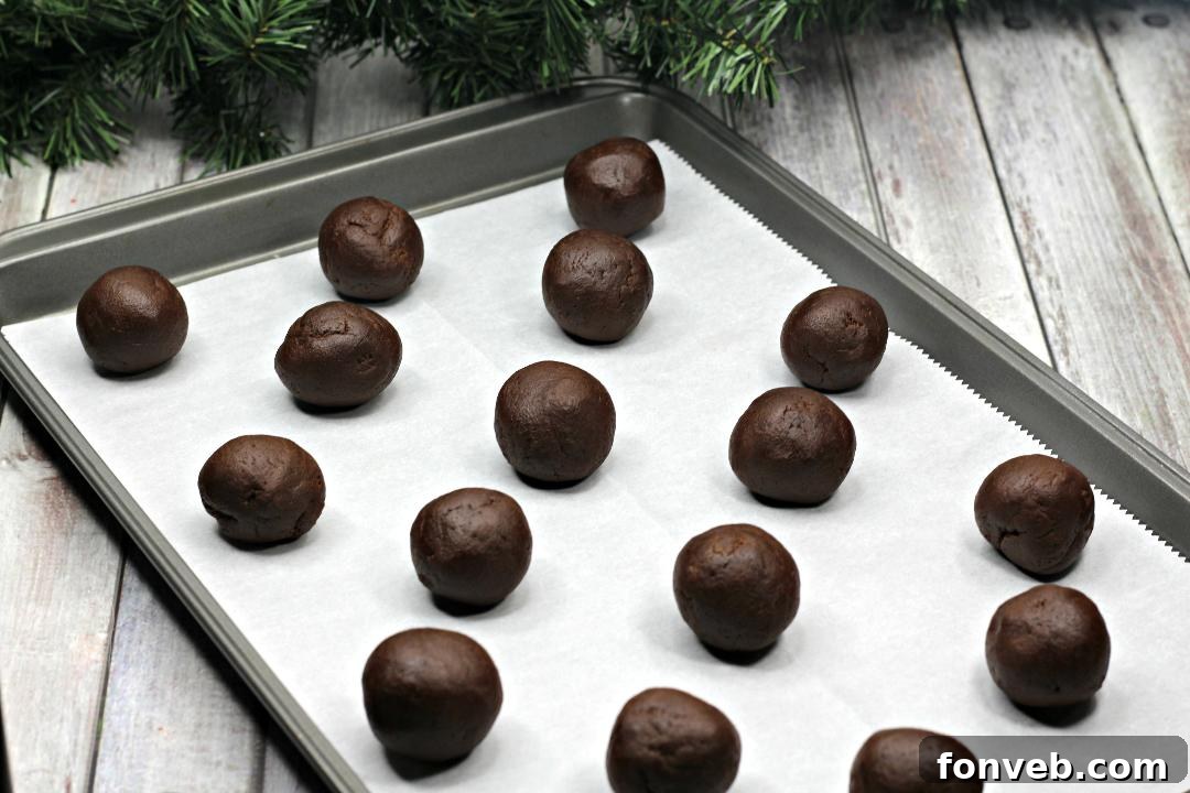 Chewy Turtle Thumbprint Delights 3 Rolling chocolate cookie dough balls in chopped pecans.
