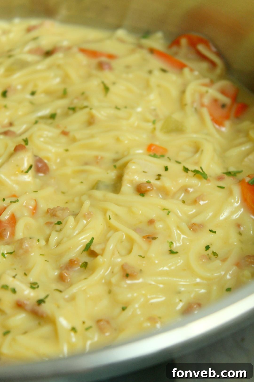 Irresistibly Creamy Chicken Noodle Soup 5 Crack Chicken Noodle Soup served in a white bowl with a sprig of fresh herbs