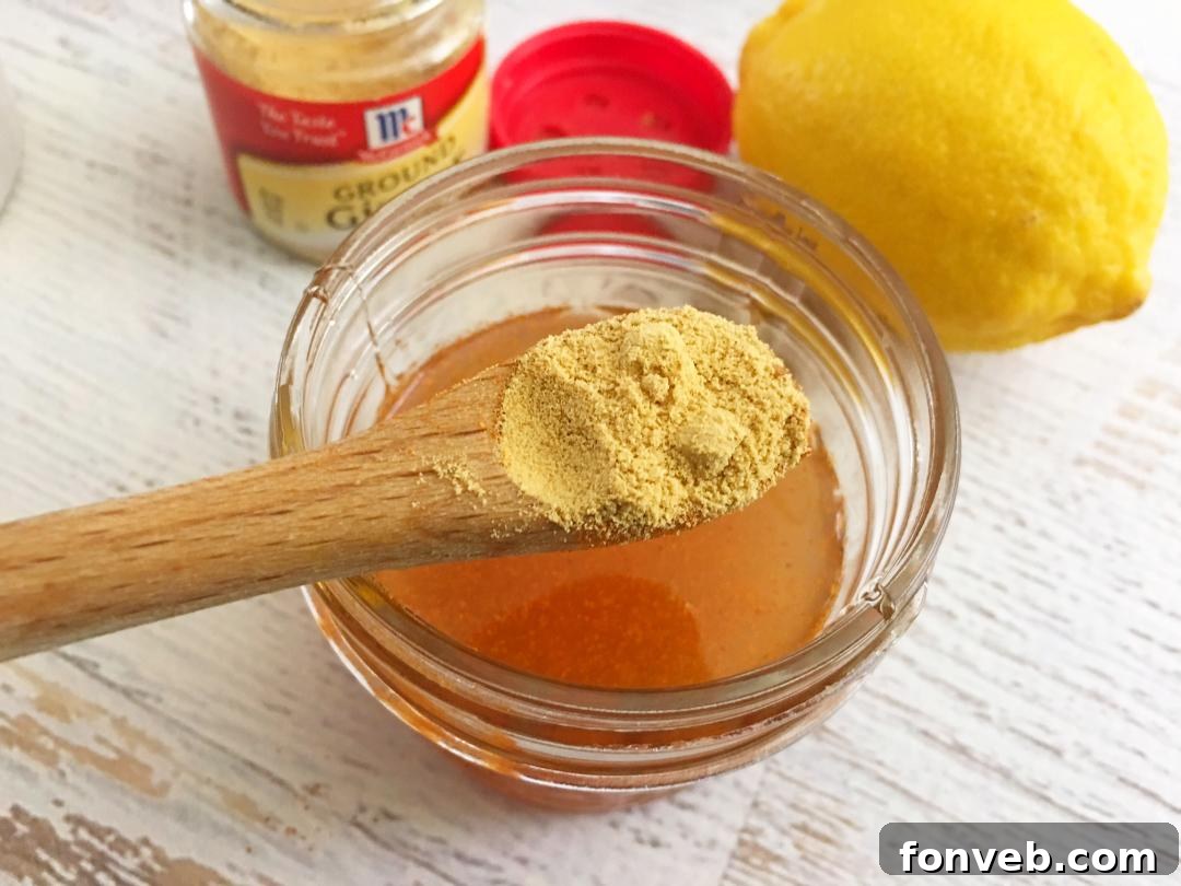 The ingredients for homemade cough syrup laid out: apple cider vinegar, honey, lemons, and ginger.