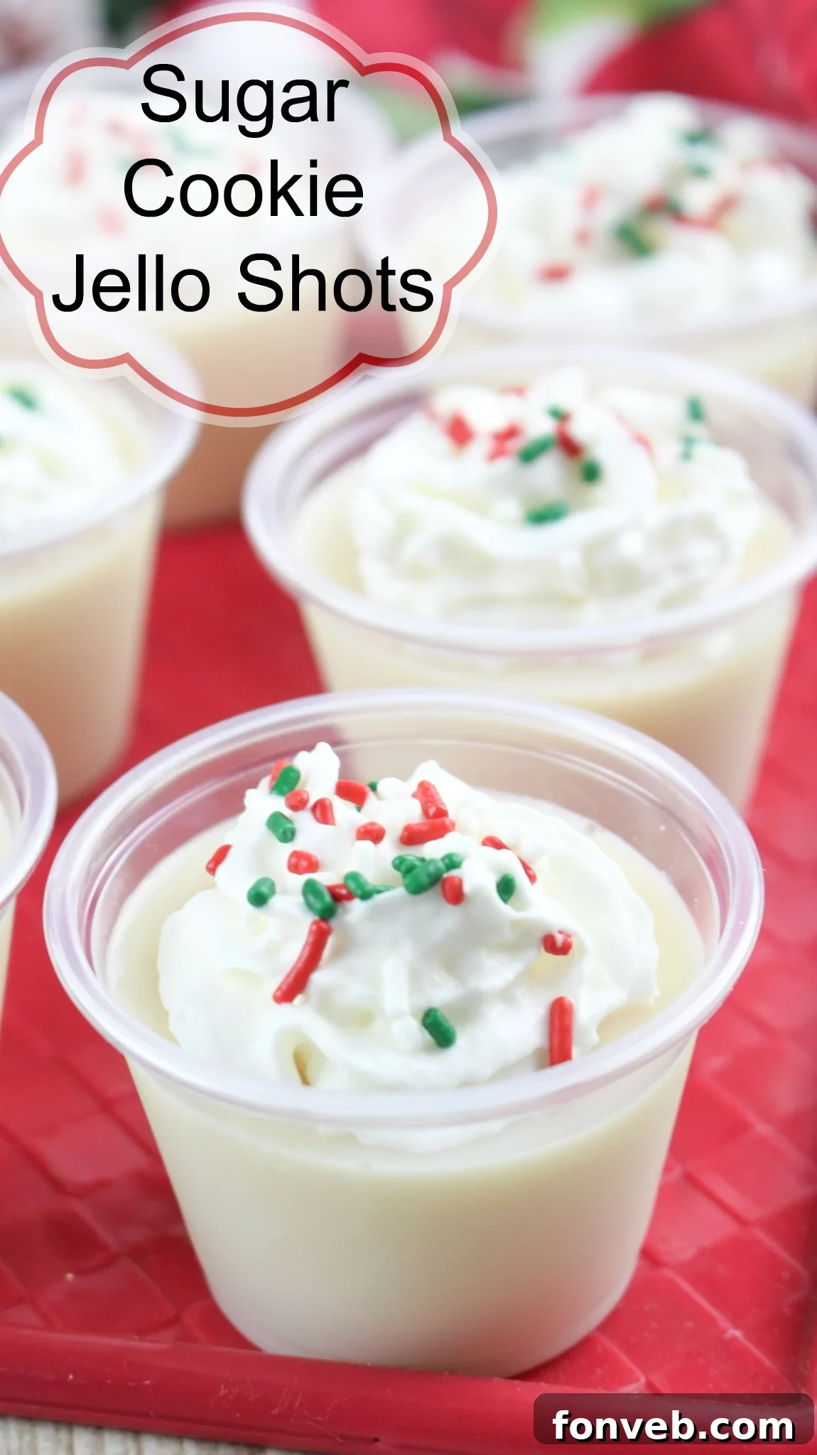Delicious Christmas Sugar Cookie Jello Shots in small cups, topped with whipped cream and festive sprinkles, ready for a holiday party.