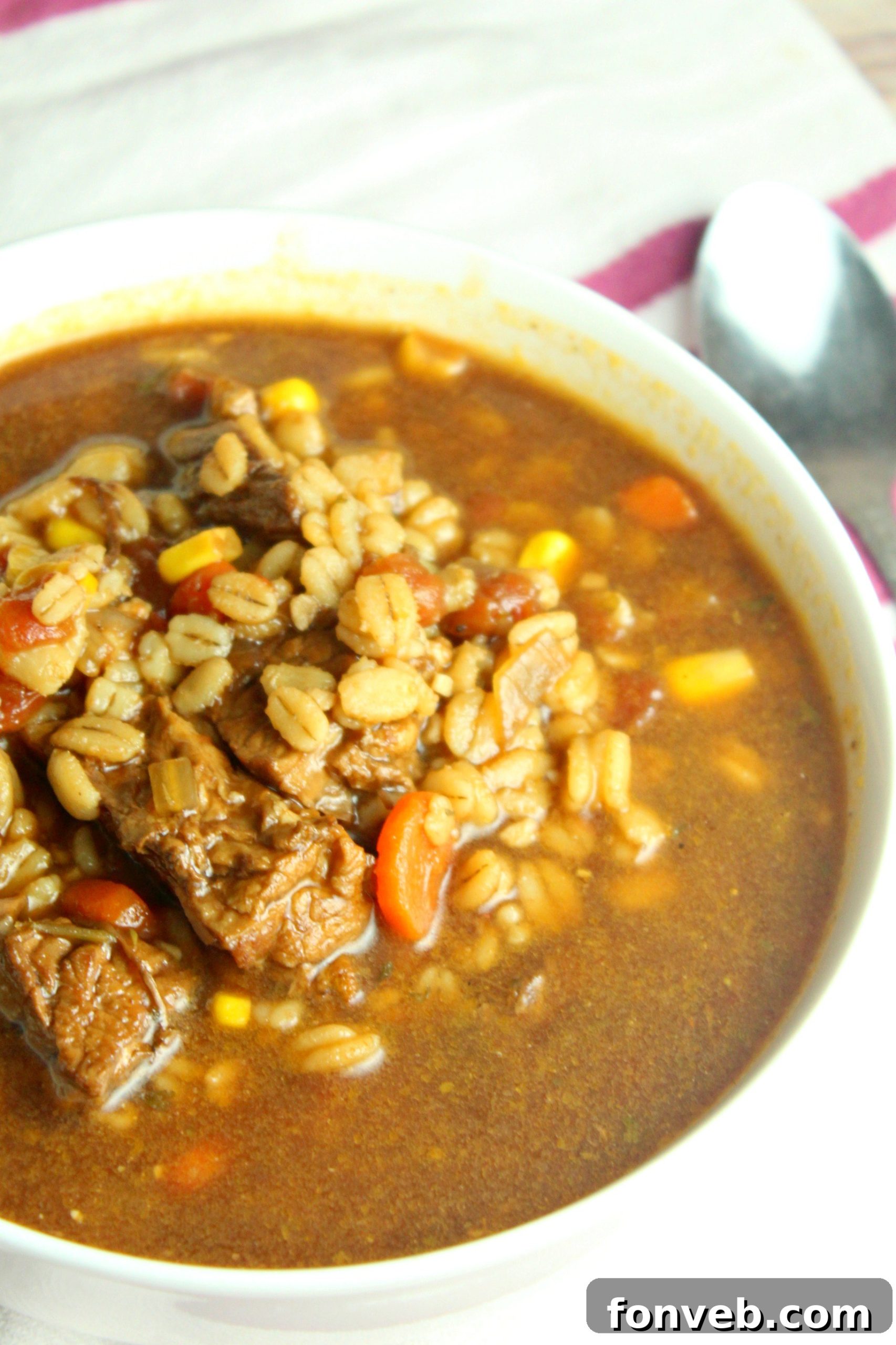 Hearty Slow Cooker Beef and Barley Soup 5 Beef and barley soup beautifully presented with slices of golden garlic bread.