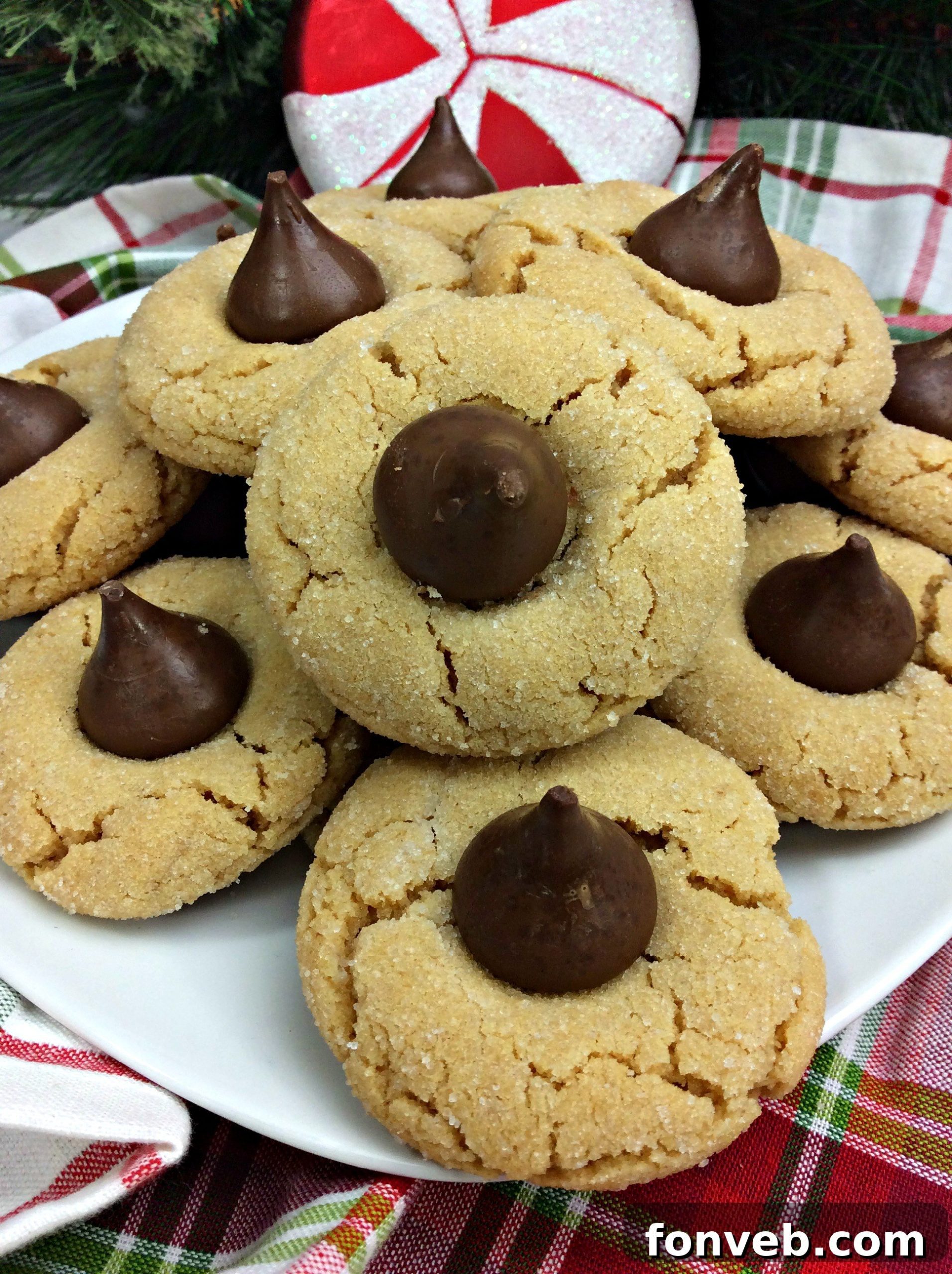 Freshly baked Peanut Butter Blossom Cookies, soft and perfectly golden brown with a melted Hershey's Kiss on top.