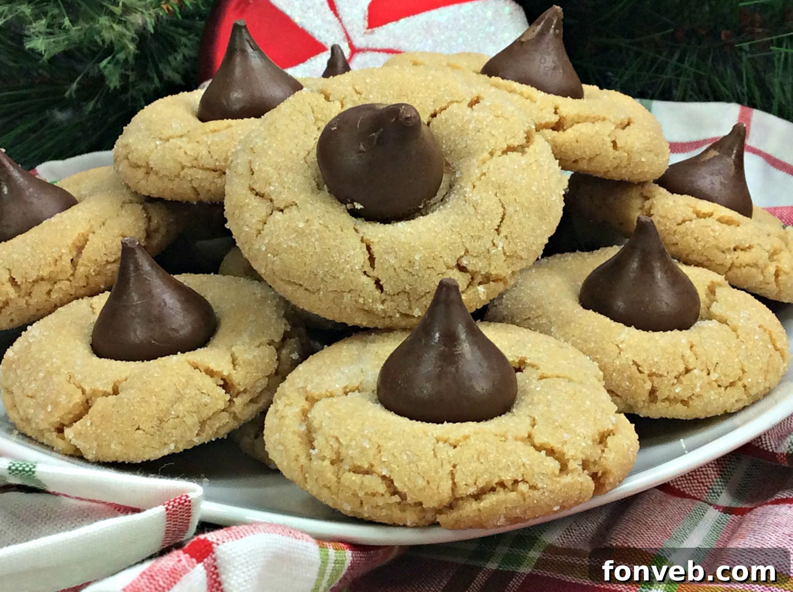 A close-up of a stack of Peanut Butter Blossom Cookies, showcasing their delightful texture and the iconic chocolate kiss.