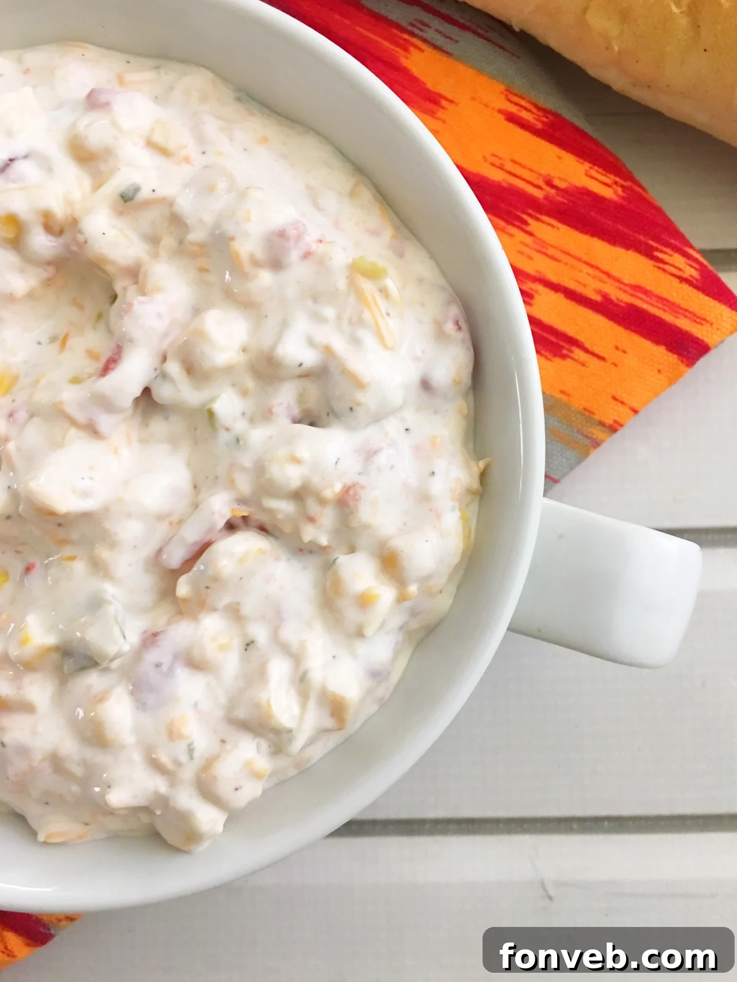 Overhead view of a bowl of Fiesta Dip with a variety of dippers like tortilla chips, crackers, and carrot sticks