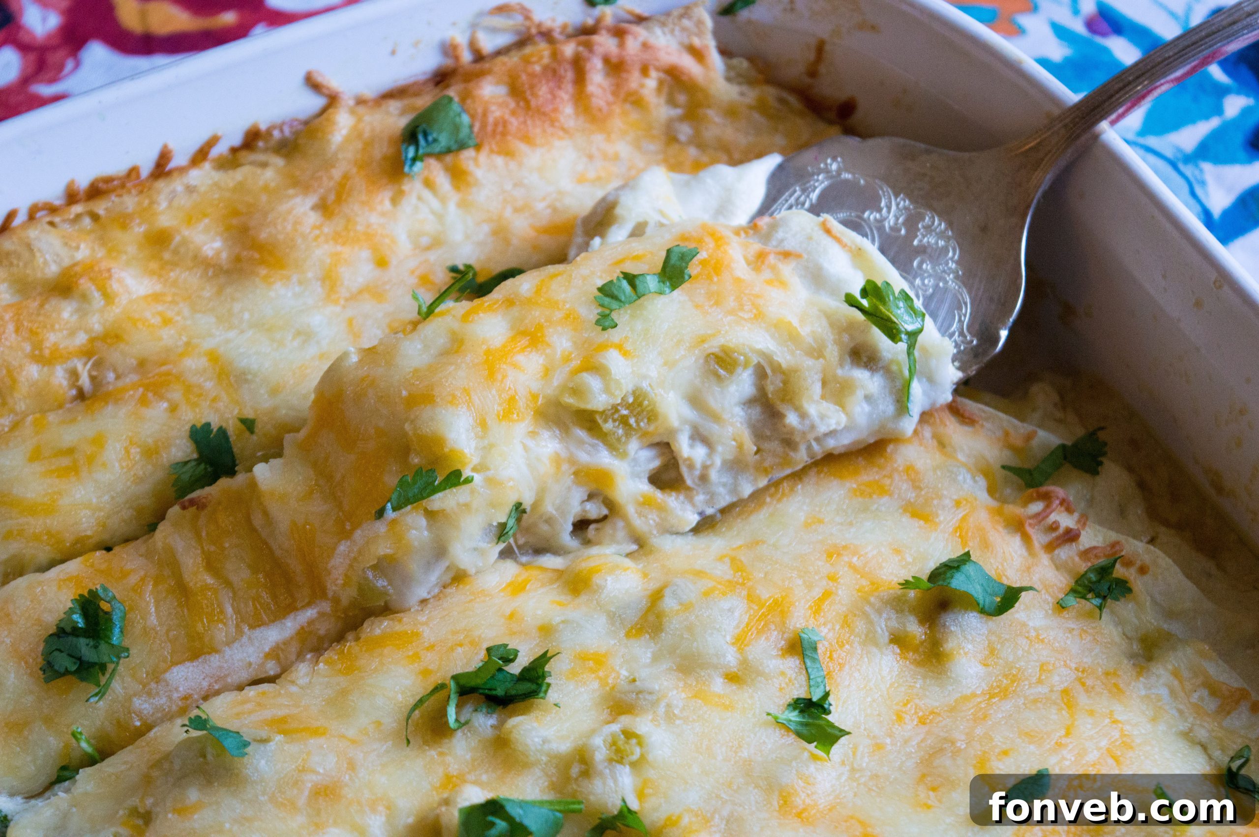 A final overhead shot of the baked white chicken enchiladas in a rectangular dish, garnished with cilantro.