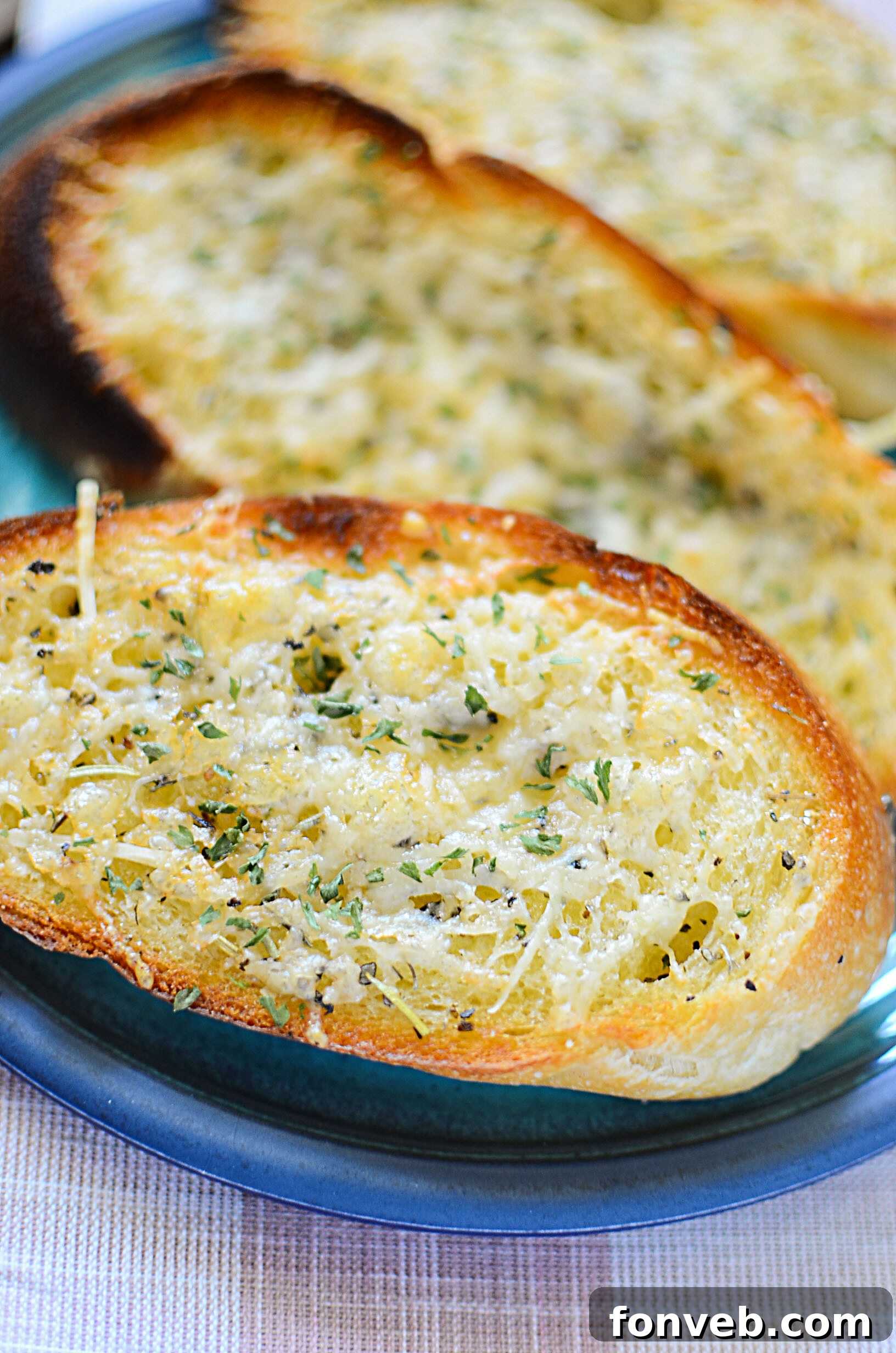 Golden brown garlic parmesan bread slices arranged on a cutting board, ready to be served