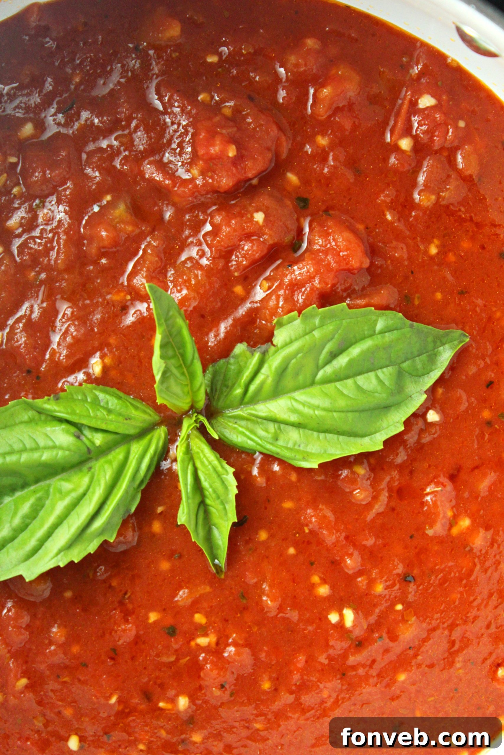 A bowl of freshly grated Parmesan cheese, ready to be added to the rich tomato sauce.