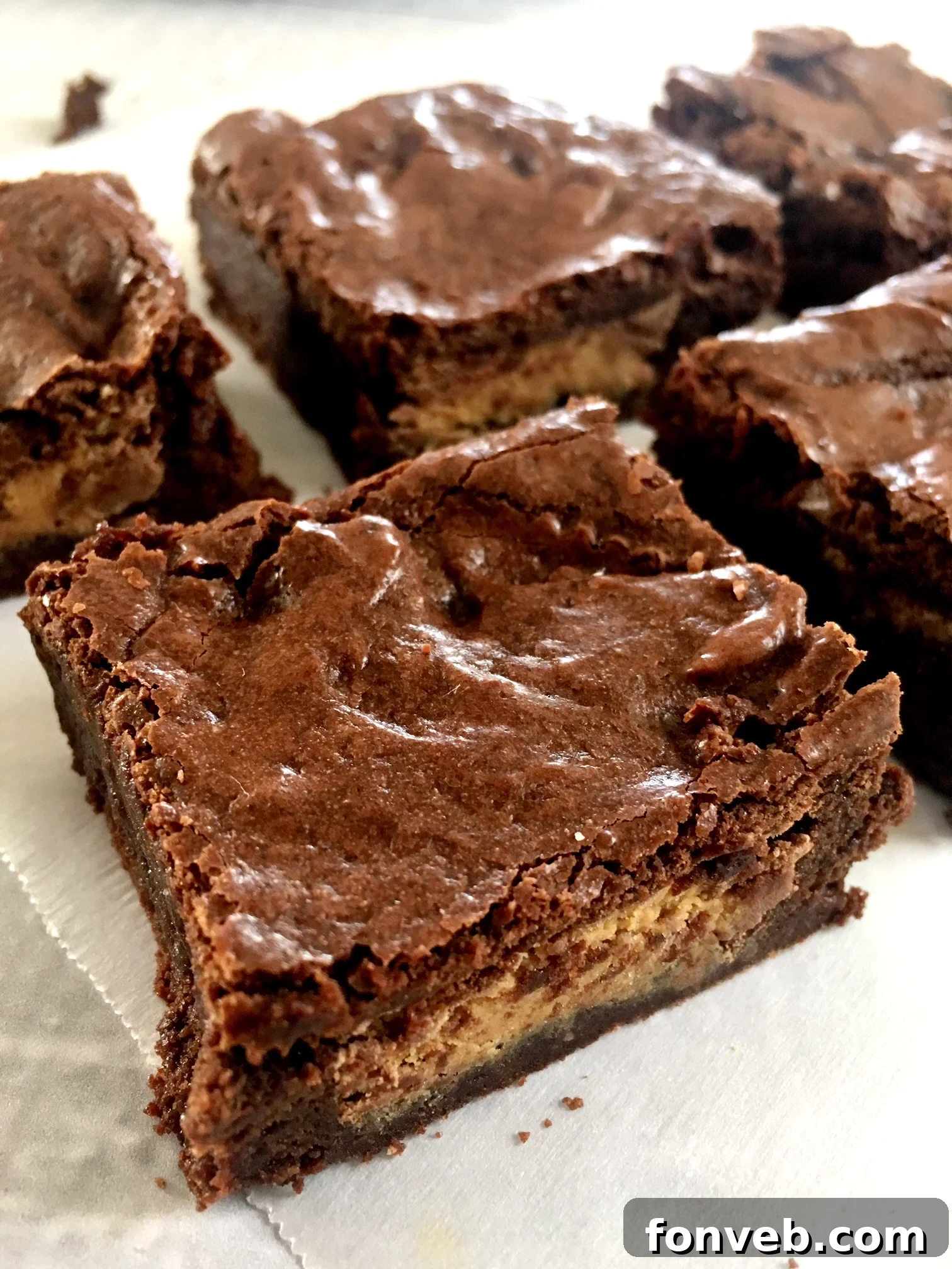 Stack of rich Reese's Peanut Butter Cup Brownies, showing their thick, decadent layers and the iconic orange wrappers.
