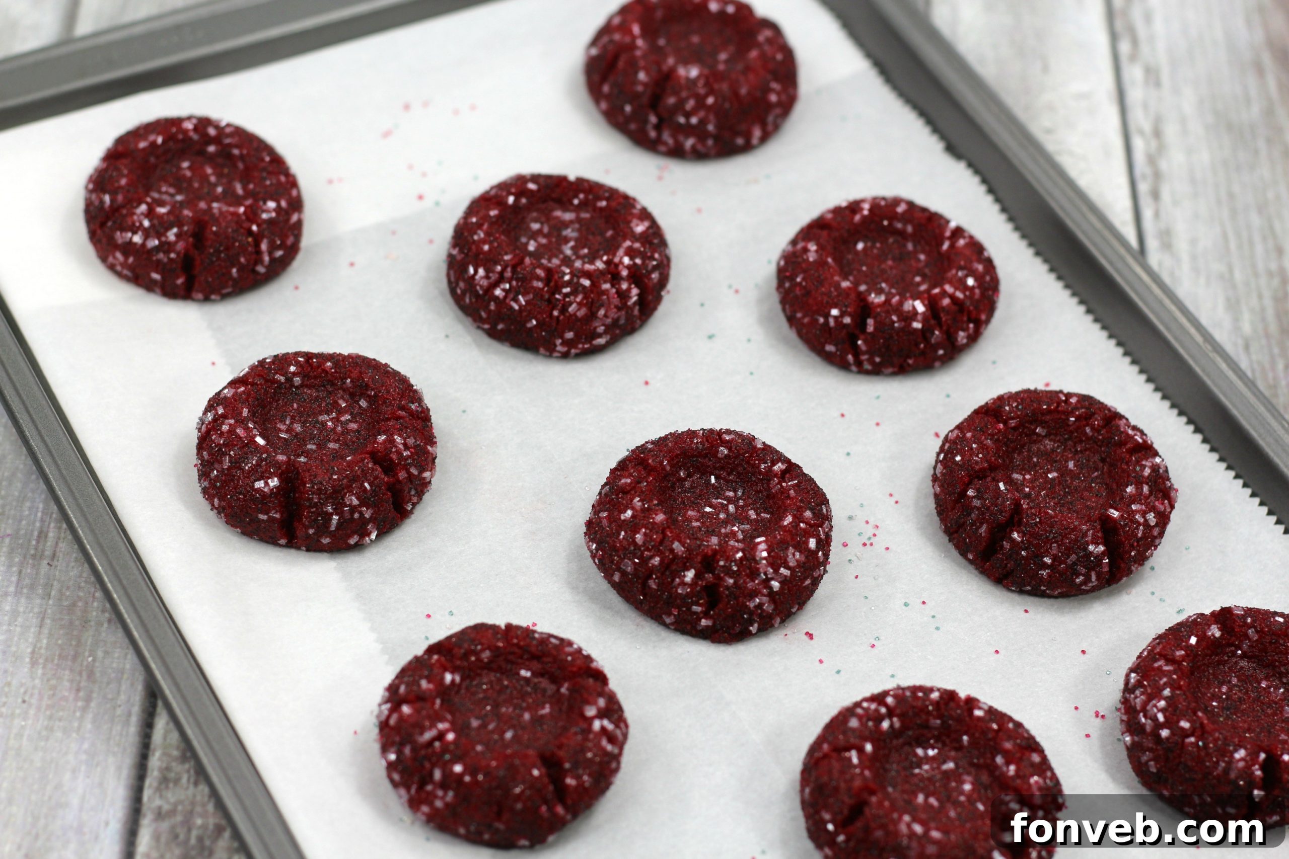 A top-down view of Red Velvet Cheesecake Thumbprint Cookies, highlighting their red color and cream cheese centers