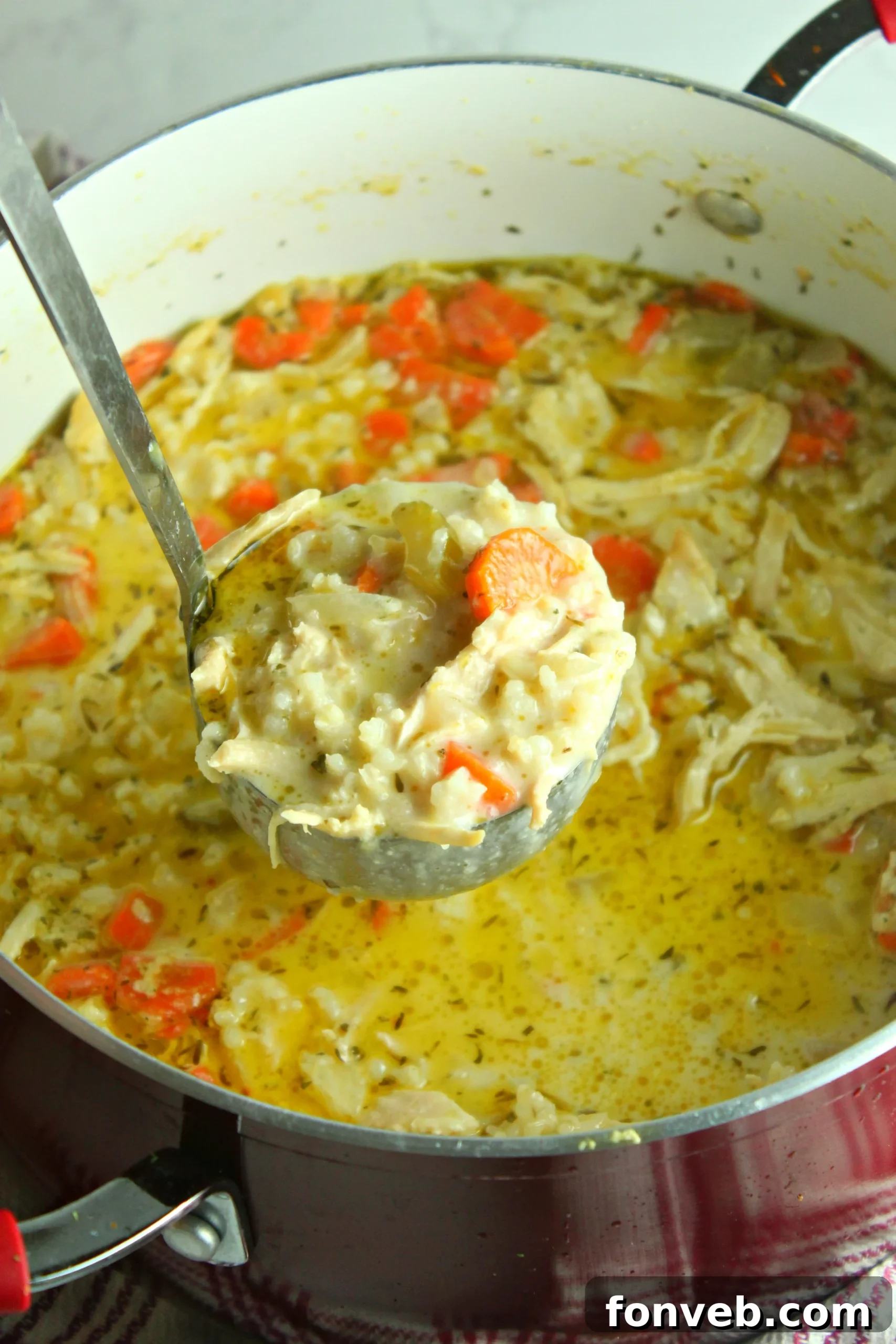 Cooked chicken and rice soup served in a rustic bowl, steam rising.