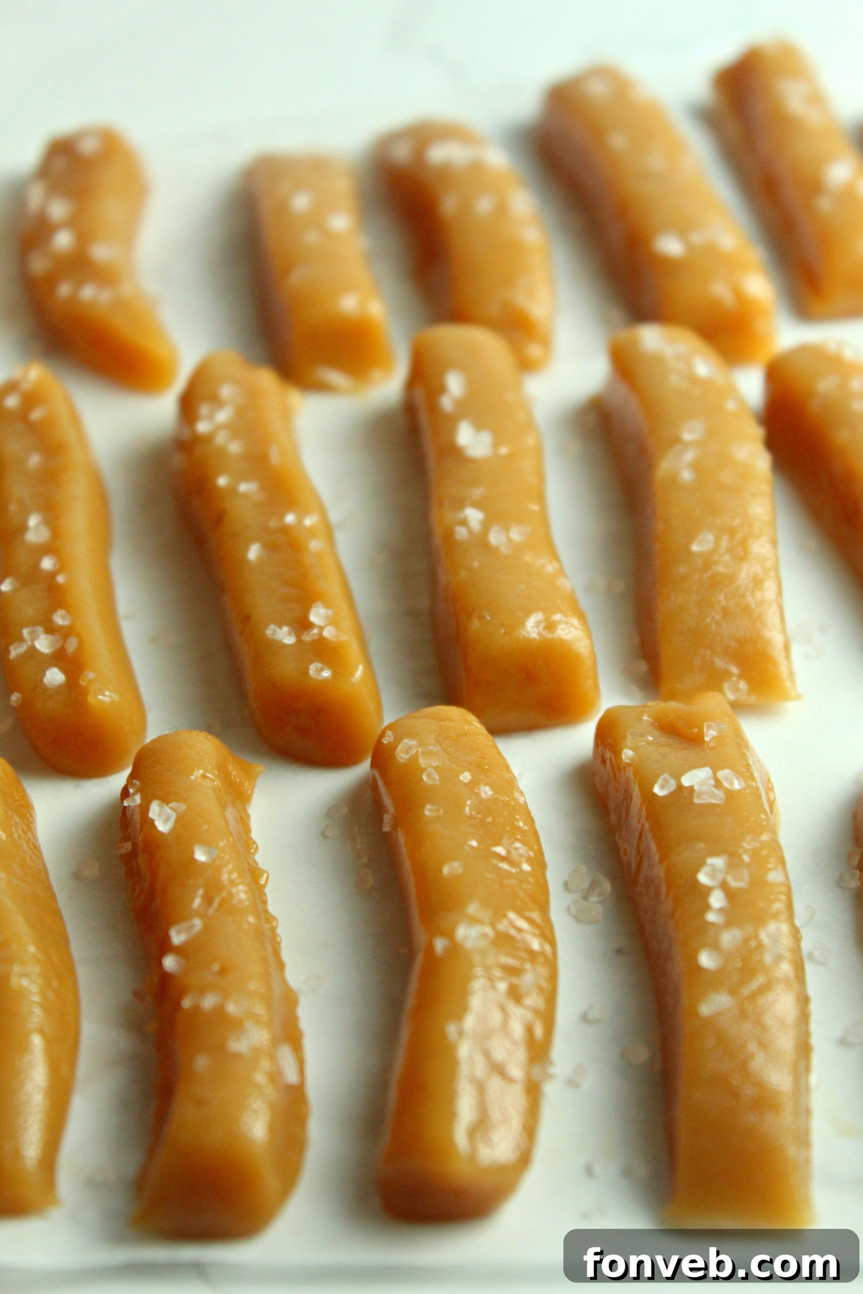 Handcrafted Salted Caramel Bliss 5 A wooden board piled high with homemade salted caramels, ready to be enjoyed or packaged.