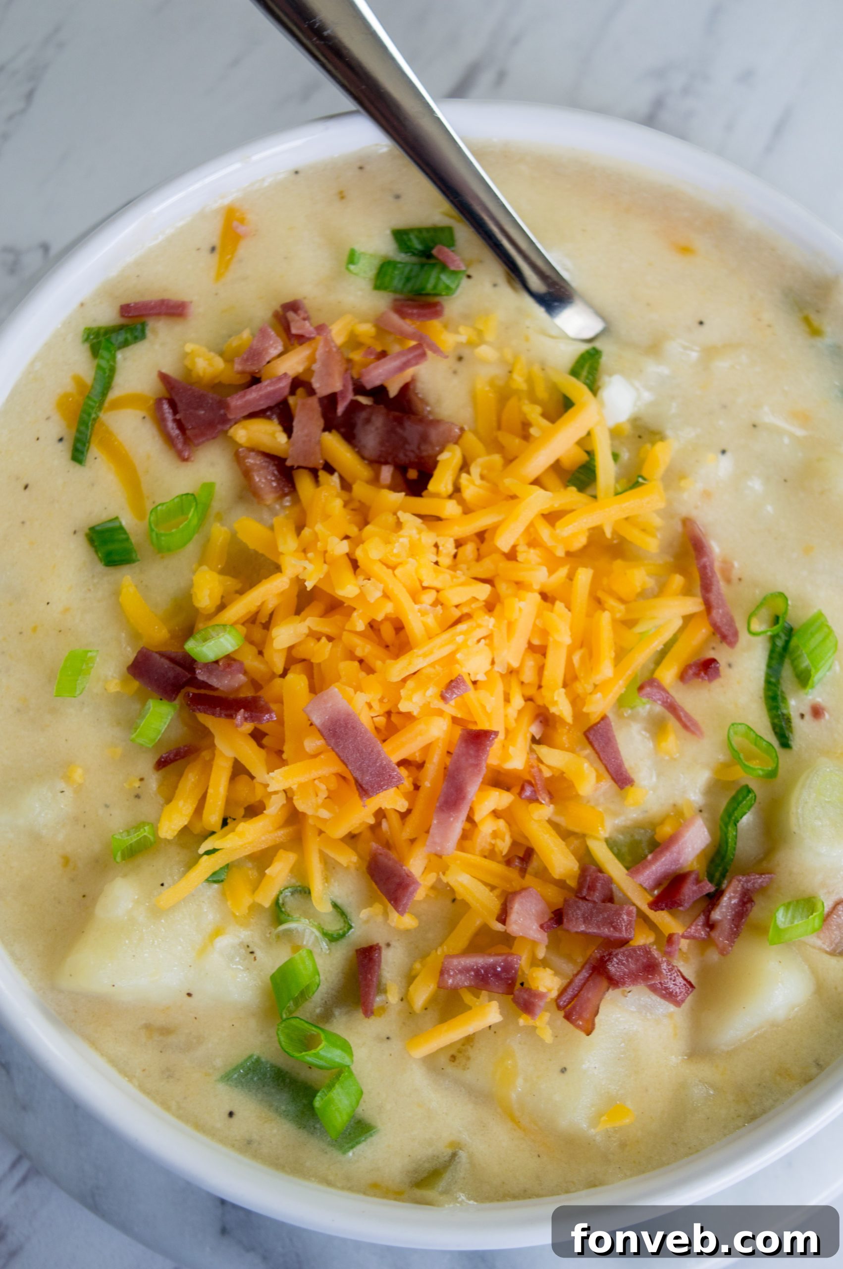 A closer view of the creamy texture of the loaded potato soup, showcasing the potato chunks and melted cheese.