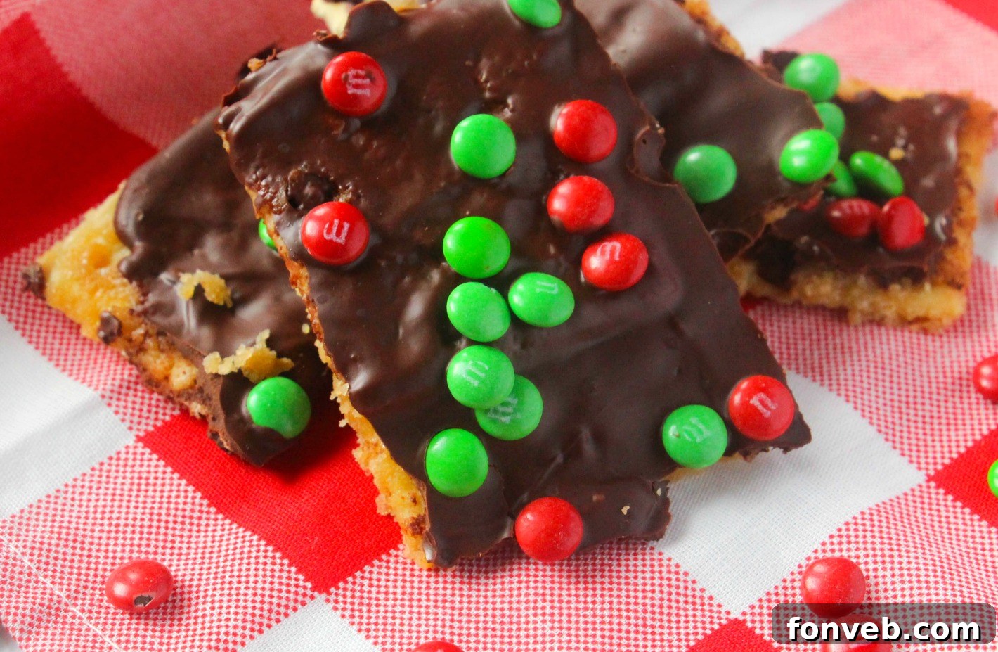 Overhead shot of Christmas Crack arranged on a white serving plate, showing the distinct layers of cracker, toffee, and chocolate with M&Ms.