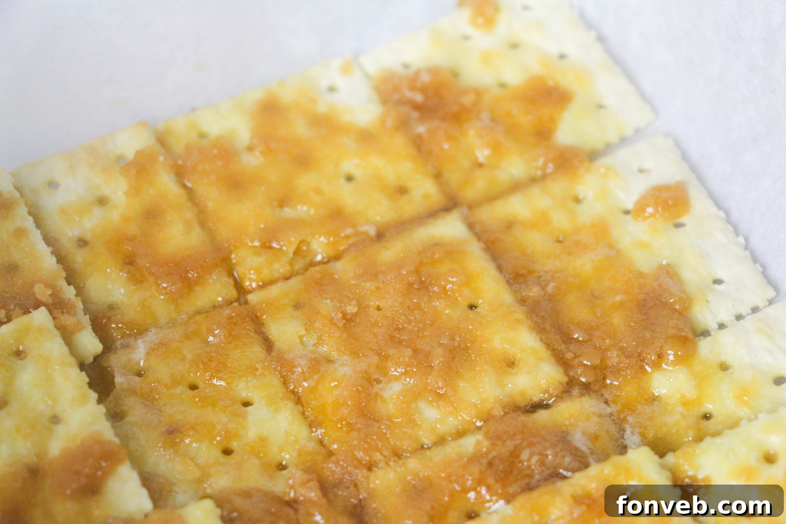 A close-up view of the Christmas Crack, showing the gooey caramel absorbed by the saltine crackers before the chocolate is added.