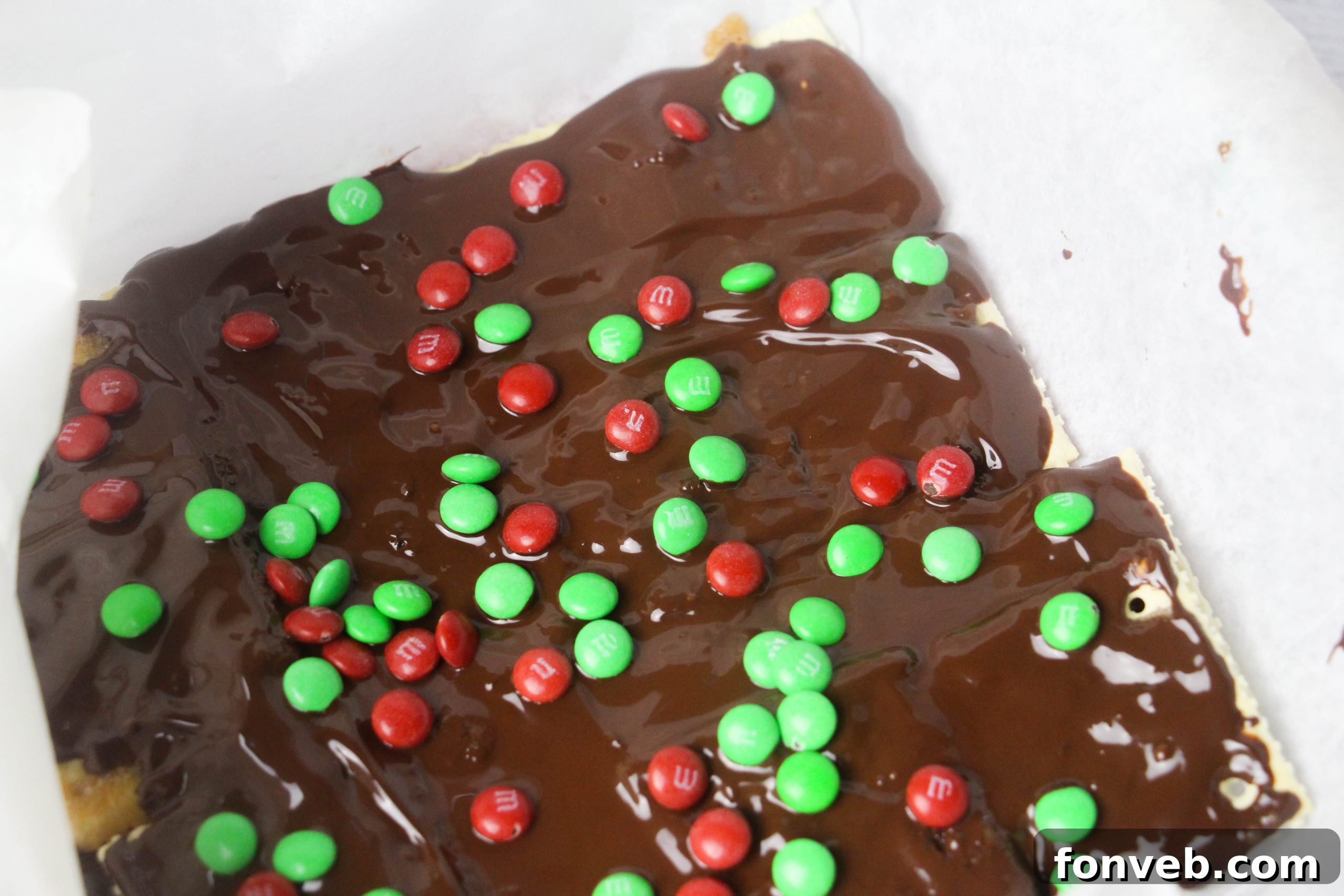 A close-up of Christmas Crack featuring a generous topping of M&Ms and perhaps other festive candies, perfect for holiday gifting.
