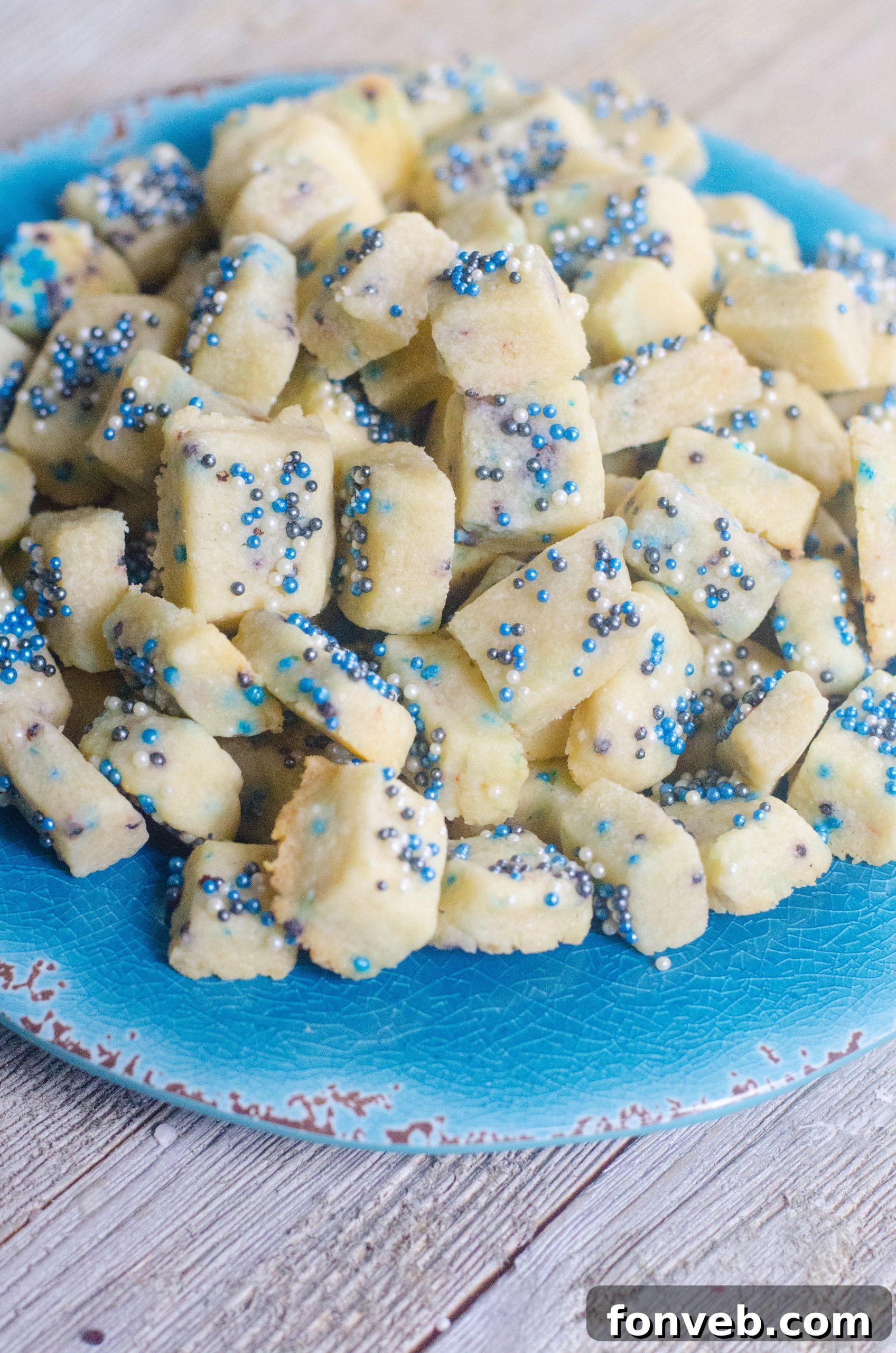 Buttery Winter Shortbread Minis 5 Assorted Winter Shortbread Bites on a baking sheet lined with parchment paper, showcasing their delicate sizes.