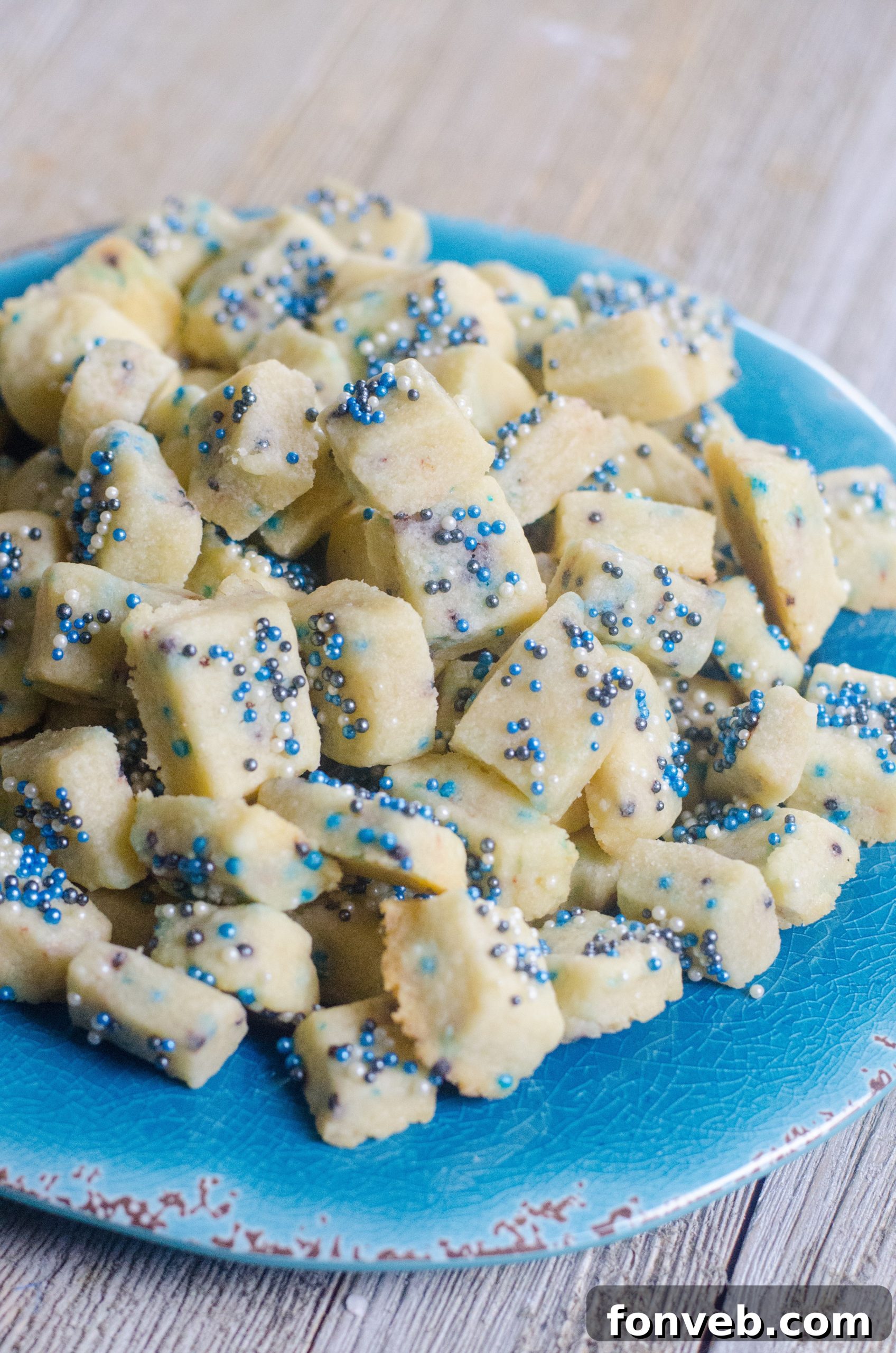 Buttery Winter Shortbread Minis 7 A beautifully composed shot of three Winter Shortbread Bites, highlighting the texture and contrasting sprinkle colors.