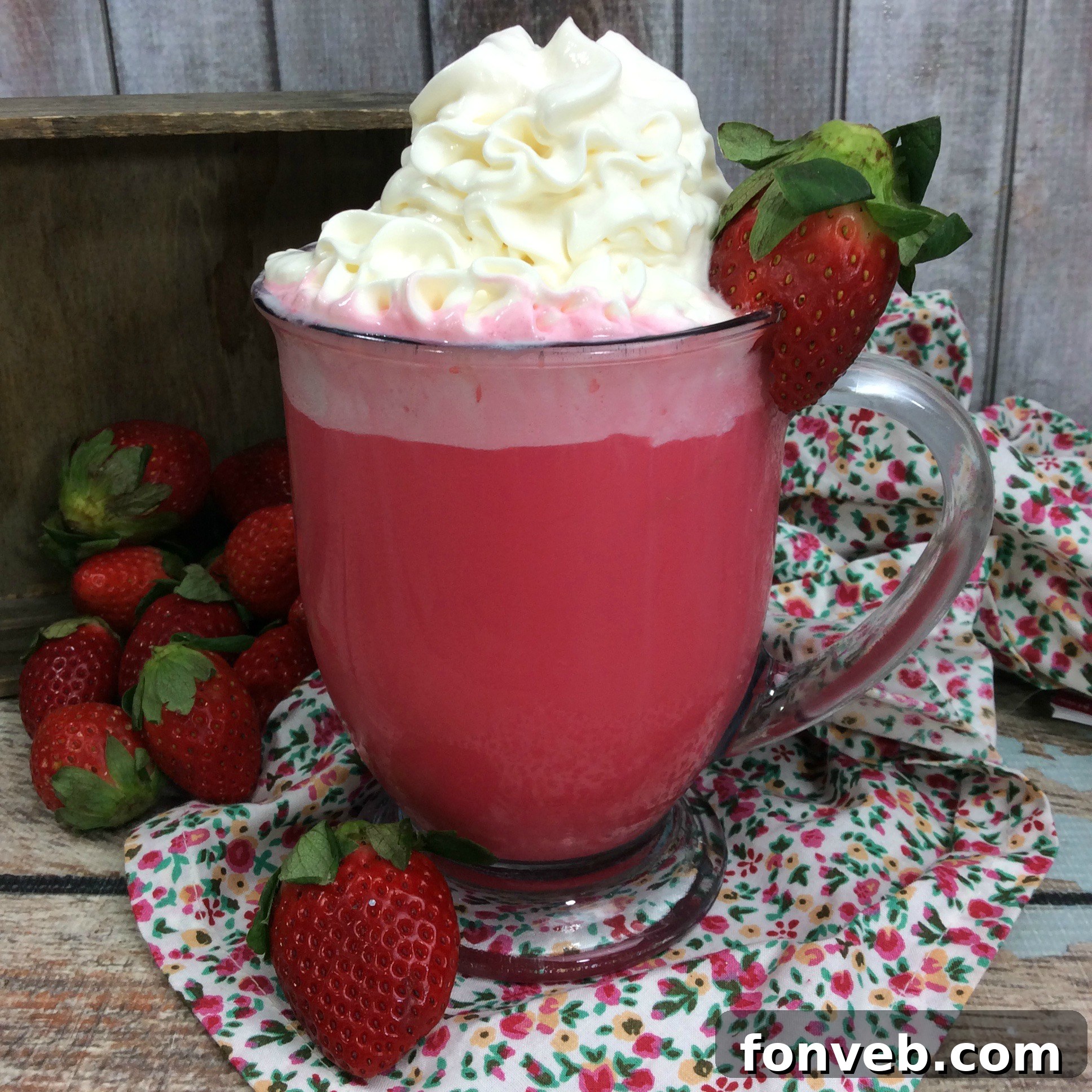 Close-up of a mug of Strawberry White Hot Cocoa garnished with fresh strawberries