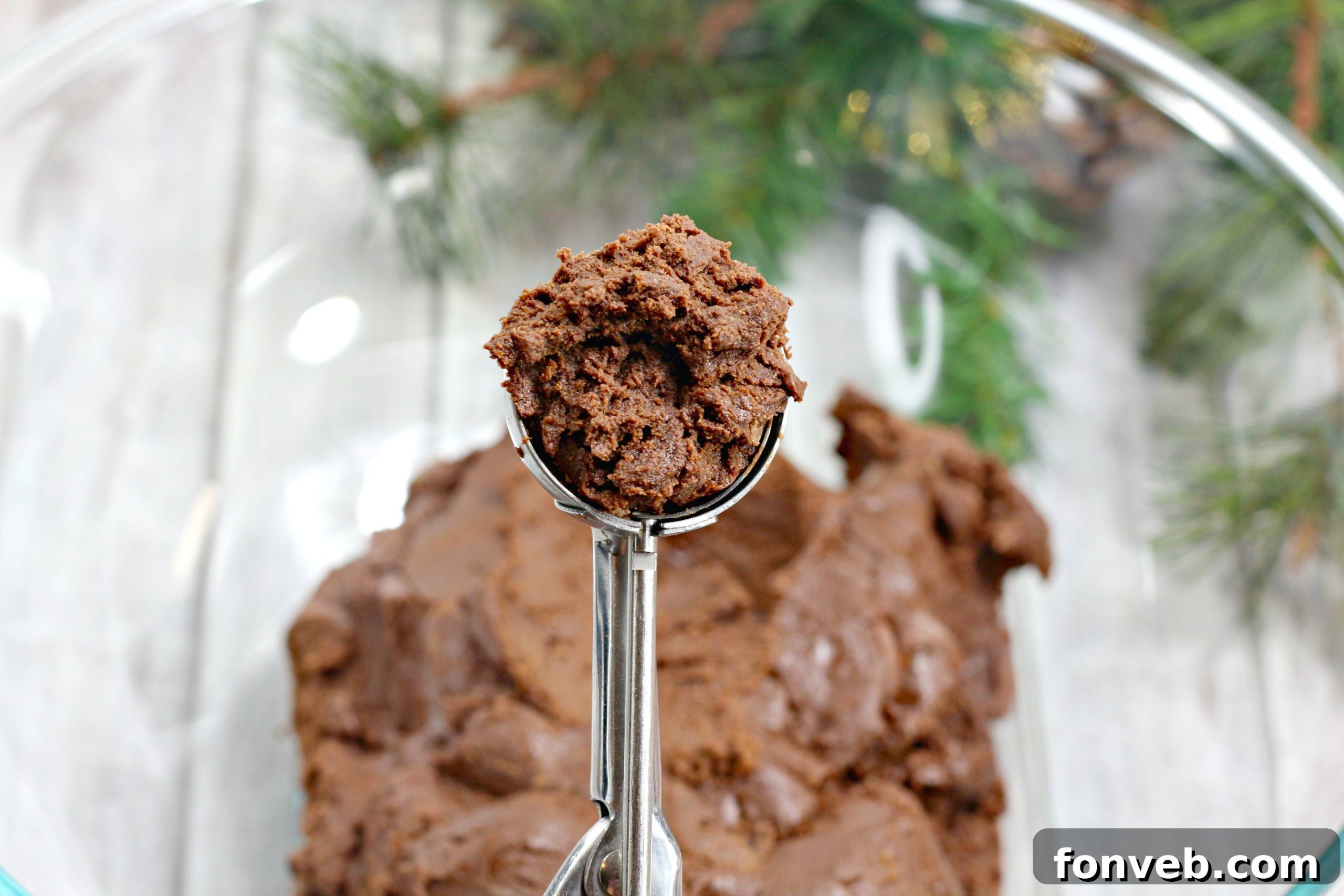 A scoop of chocolate Kahlua truffle mixture being rolled into a perfect bite-sized ball.