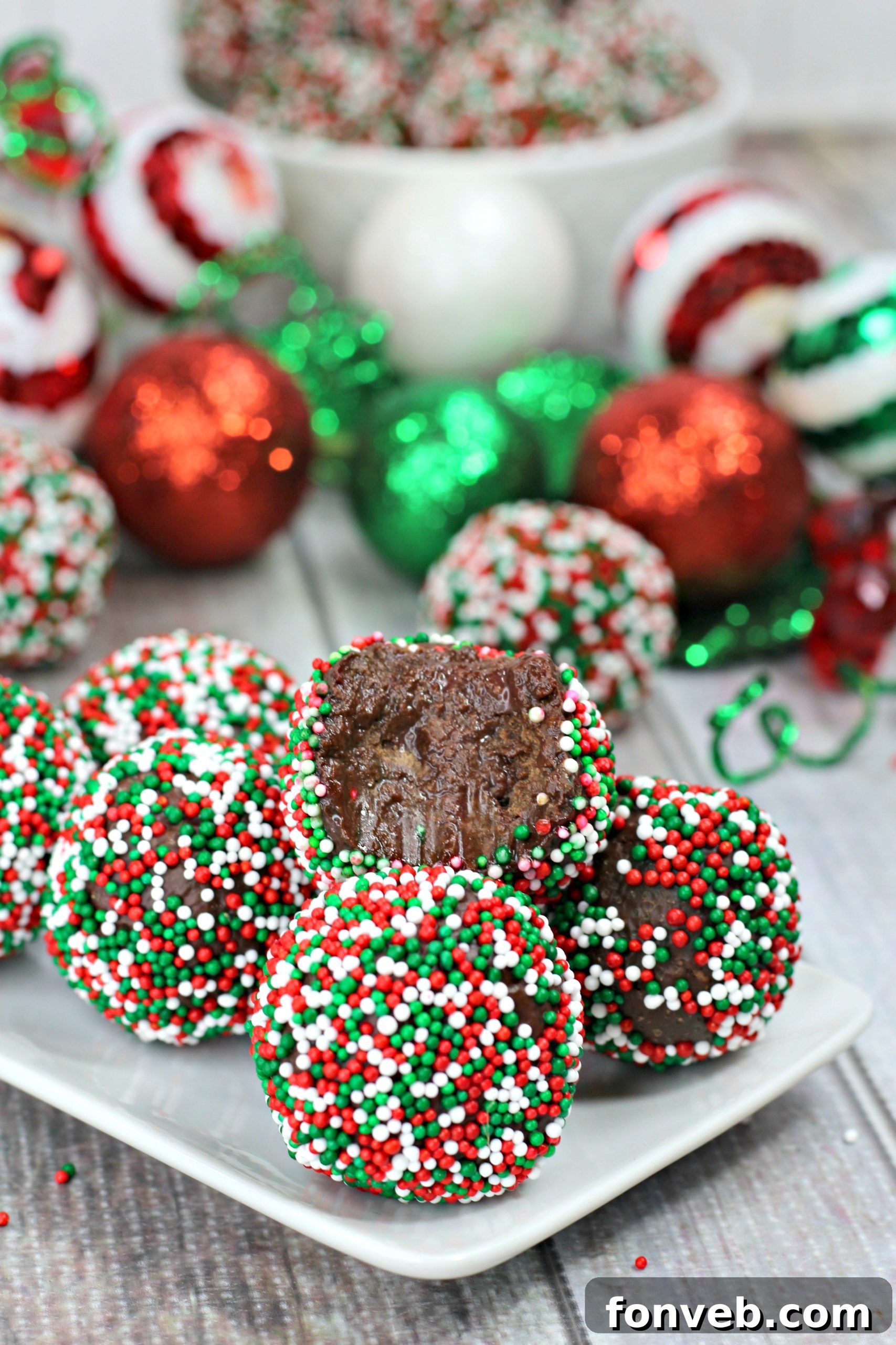 Variety of chocolate Kahlua truffles, some coated in sprinkles, others dipped in white or milk chocolate, on a parchment-lined tray.