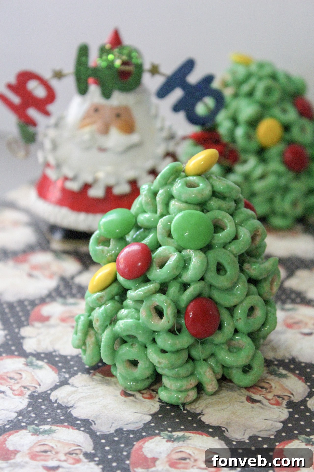 Overhead view of multiple Cheerio Christmas tree treats with various M&M decorations