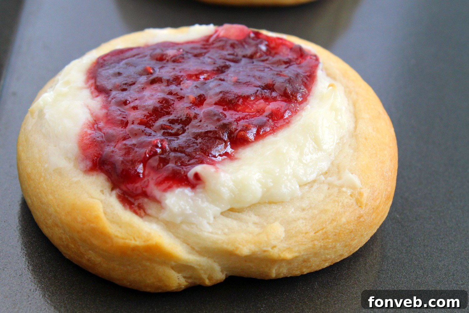 Freshly baked raspberry cream cheese crescent danishes on a cooling rack.