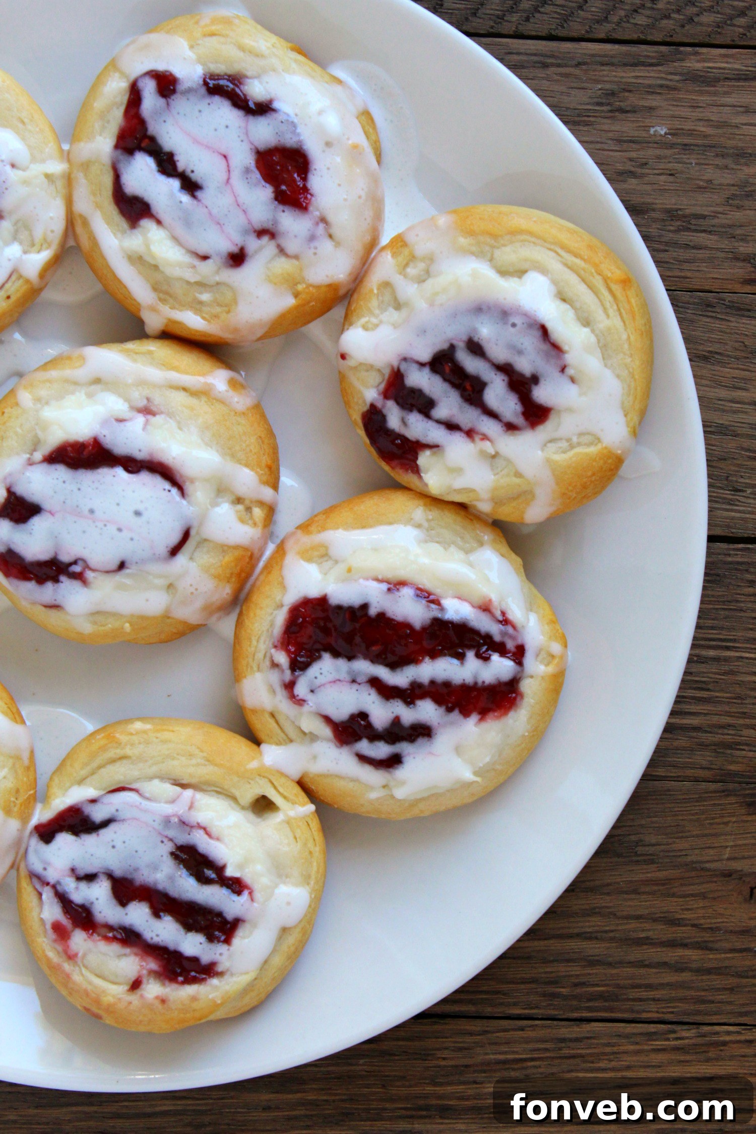 Close-up of two baked danishes with glaze drizzled on top.