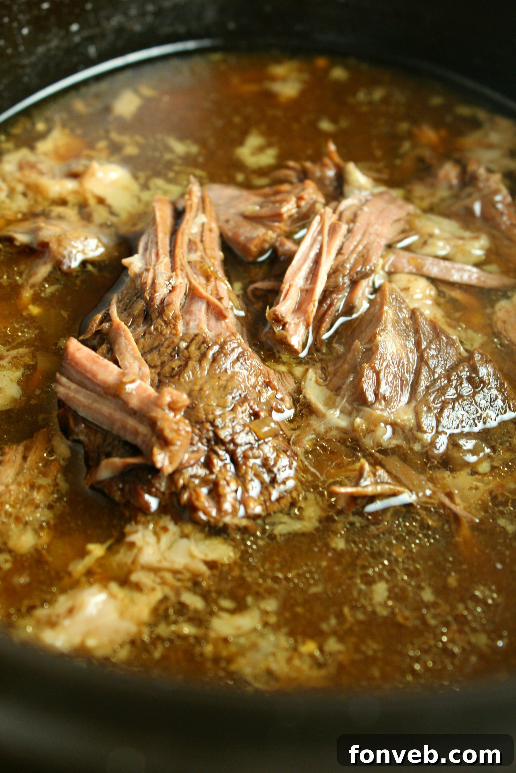 Close-up of a French Dip sandwich with shredded beef and melted provolone cheese, showing its delicious texture.