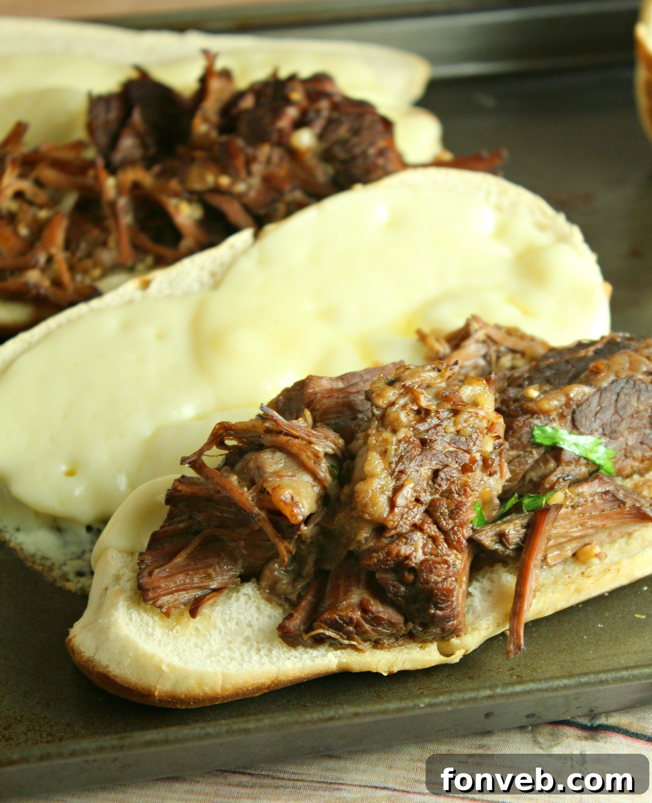 The beef simmering in the slow cooker, ready to be shredded, showing the rich, dark color of the broth.