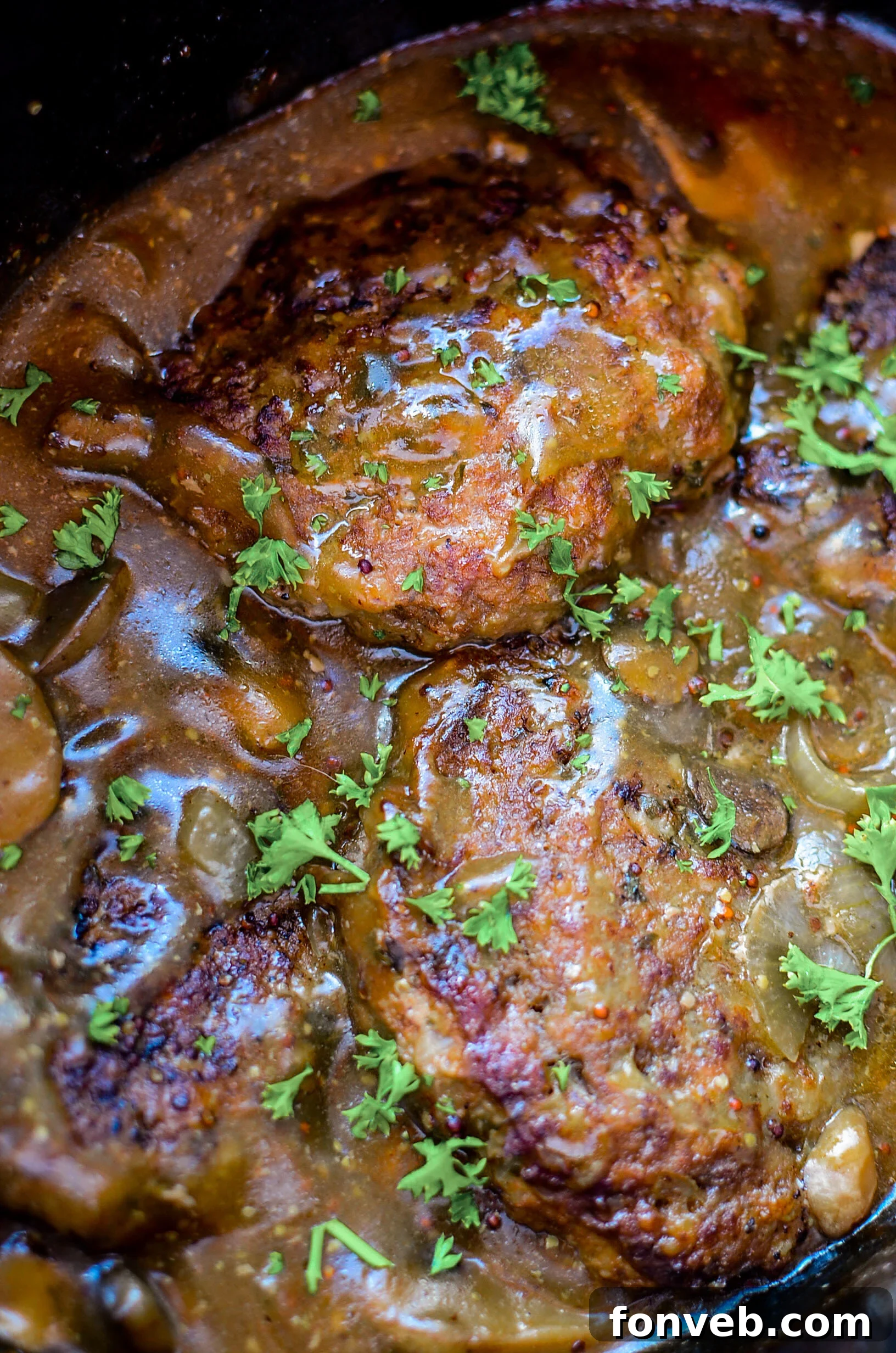 Delicious Slow Cooker Salisbury Steaks served over creamy mashed potatoes, topped with savory gravy and sliced mushrooms.