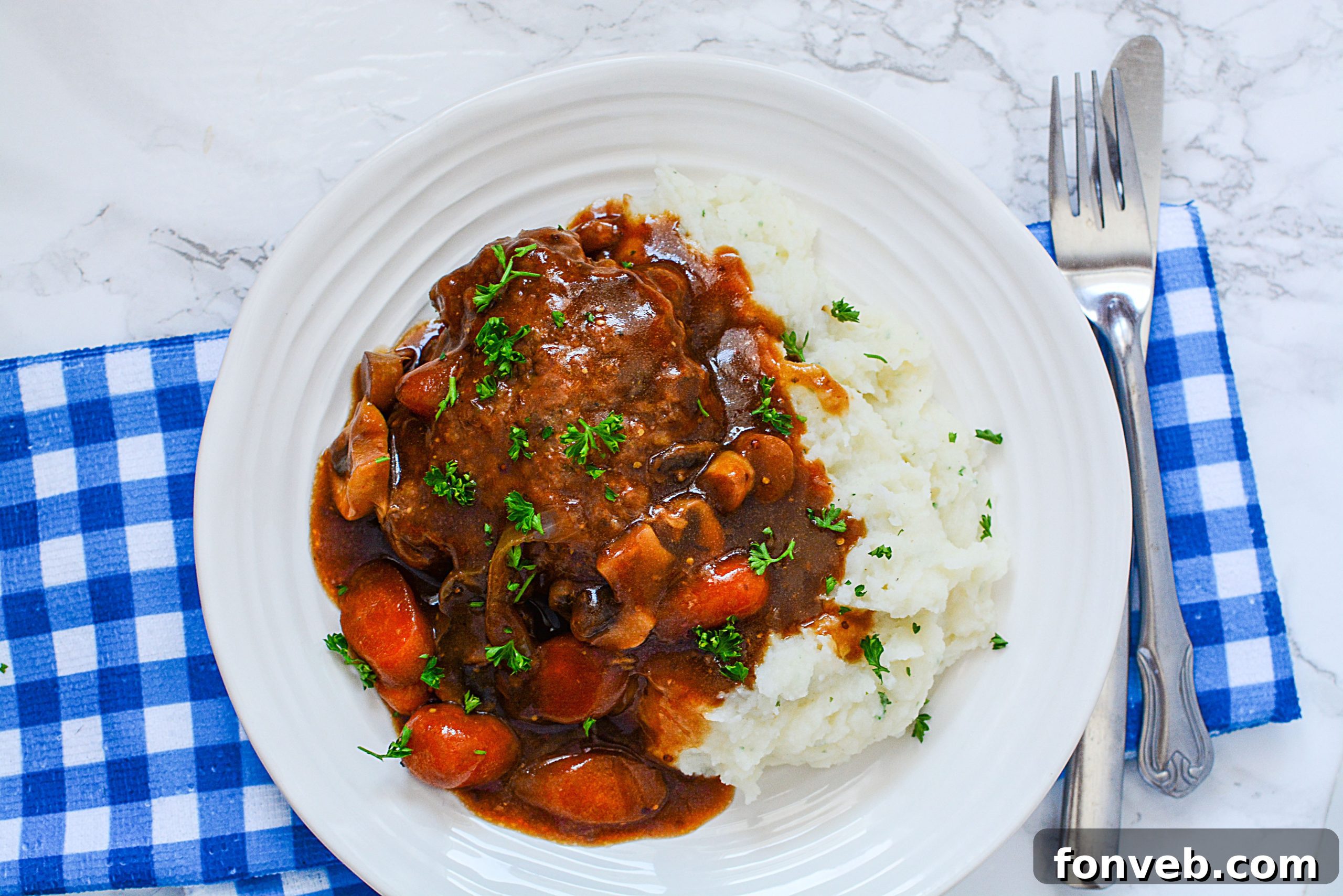 Three Salisbury steak patties generously covered in gravy, nestled in a slow cooker with sliced onions and mushrooms.