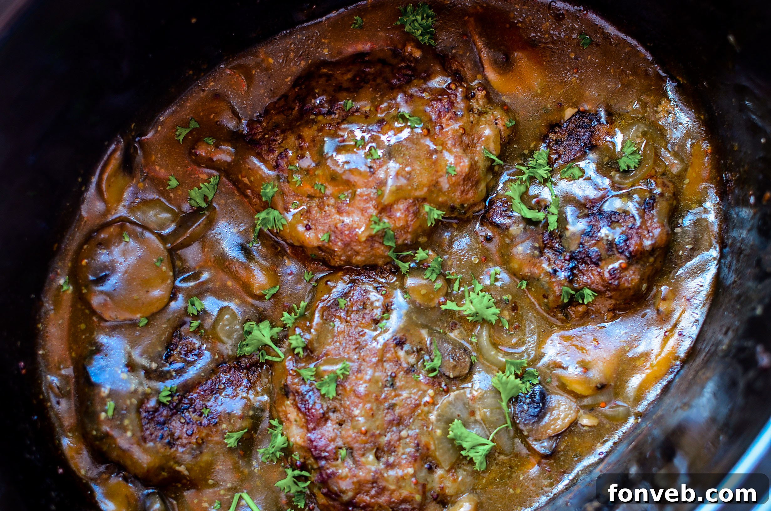 A wide shot of Salisbury steak patties cooking in a slow cooker, illustrating the ease and convenience of the cooking method.