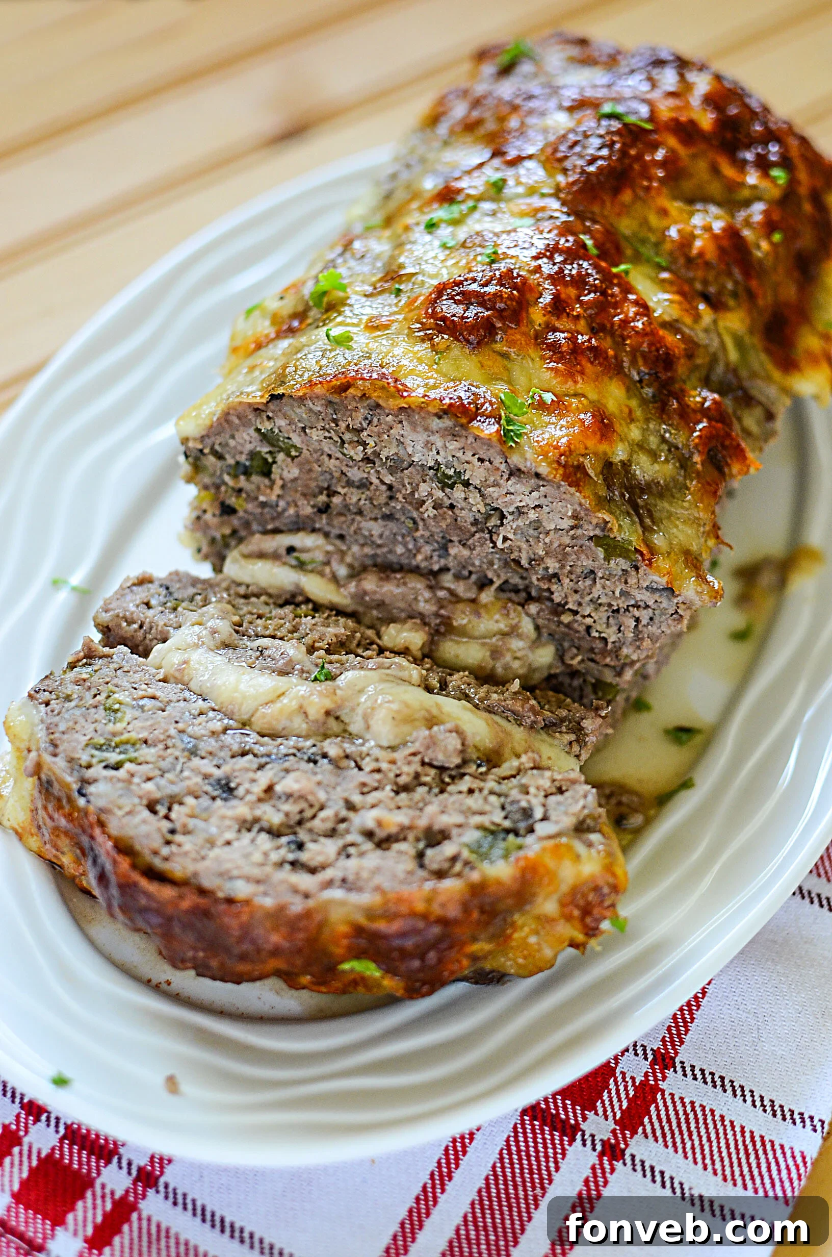 Slices of juicy Philly Cheesesteak Meatloaf with melted cheese and bell peppers