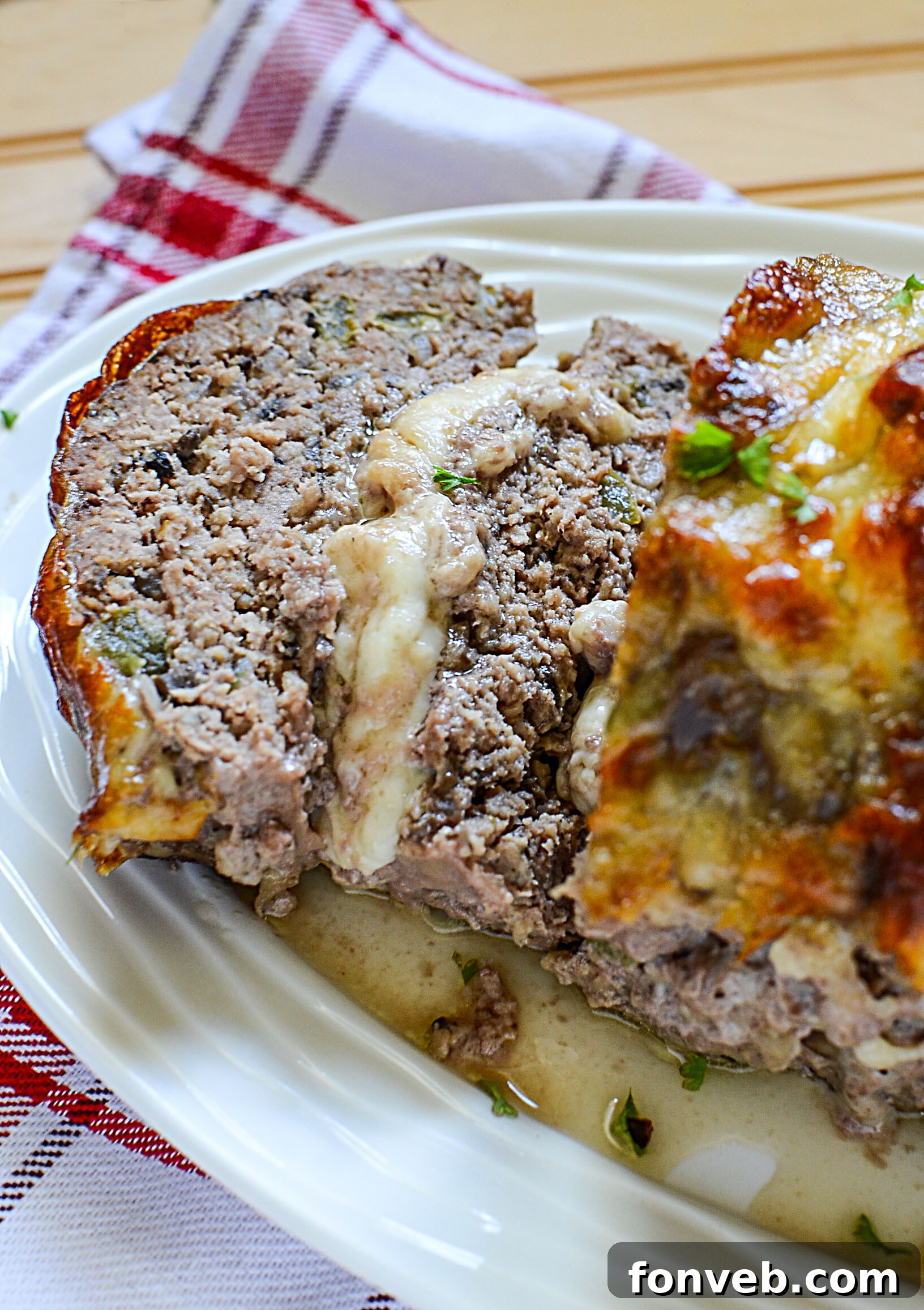 Overhead shot of Philly Cheesesteak Meatloaf, with steam rising, on a wooden cutting board